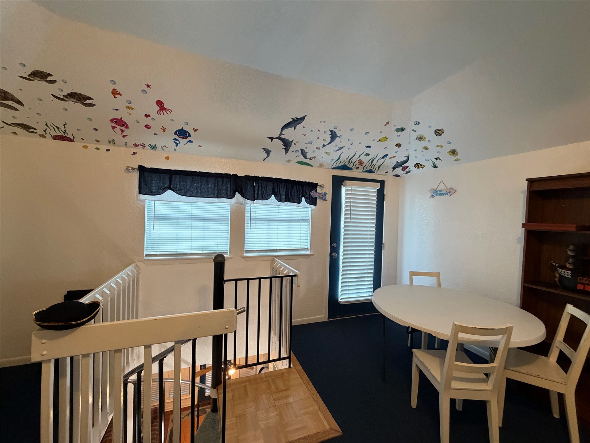 13002 Buccaneer Parkway, Freeport, TX 77541 Dive into creativity in the third-level guest room, featuring captivating under-the-sea artwork on the ceiling, complemented by a cozy table and chairs.