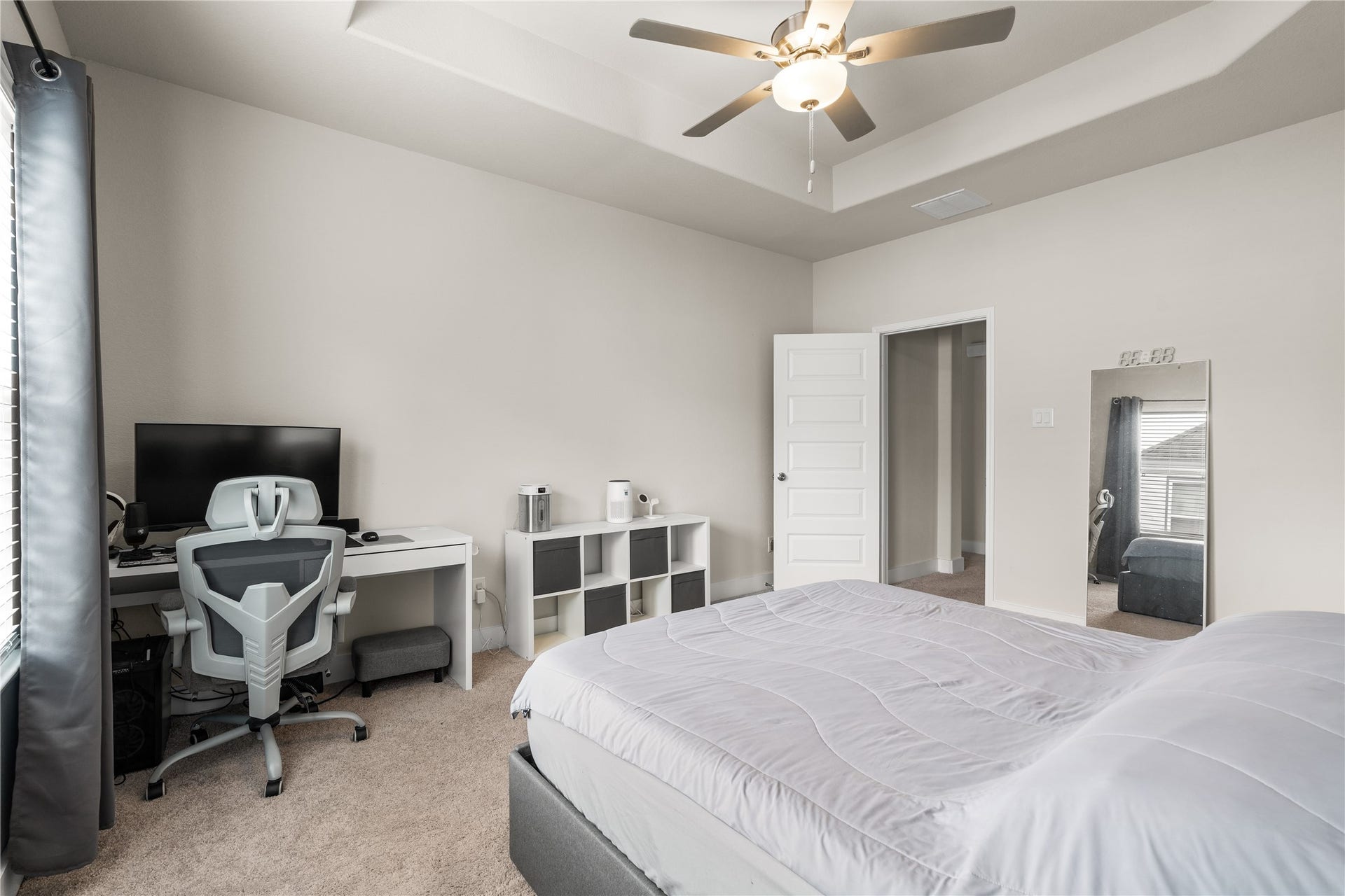 4001 Baja Lane, Houston, TX 77045 Elevated by a tray ceiling, the primary suite feels open and airy while offering ample space for both a sleeping area and a dedicated workspace or reading corner.