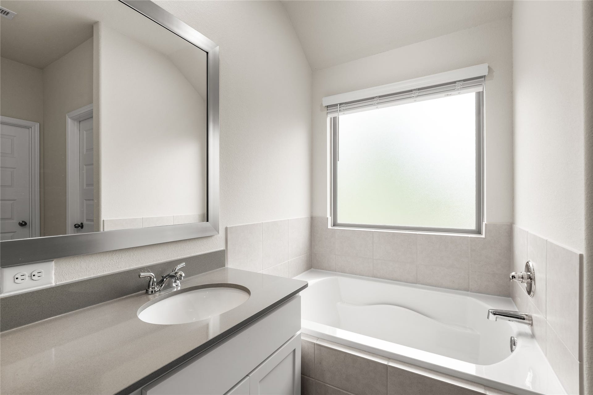 4001 Baja Lane, Houston, TX 77045 Positioned beneath a large privacy window, the soaking tub creates a bright and inviting space to unwind while allowing natural light to fill the room throughout the day.