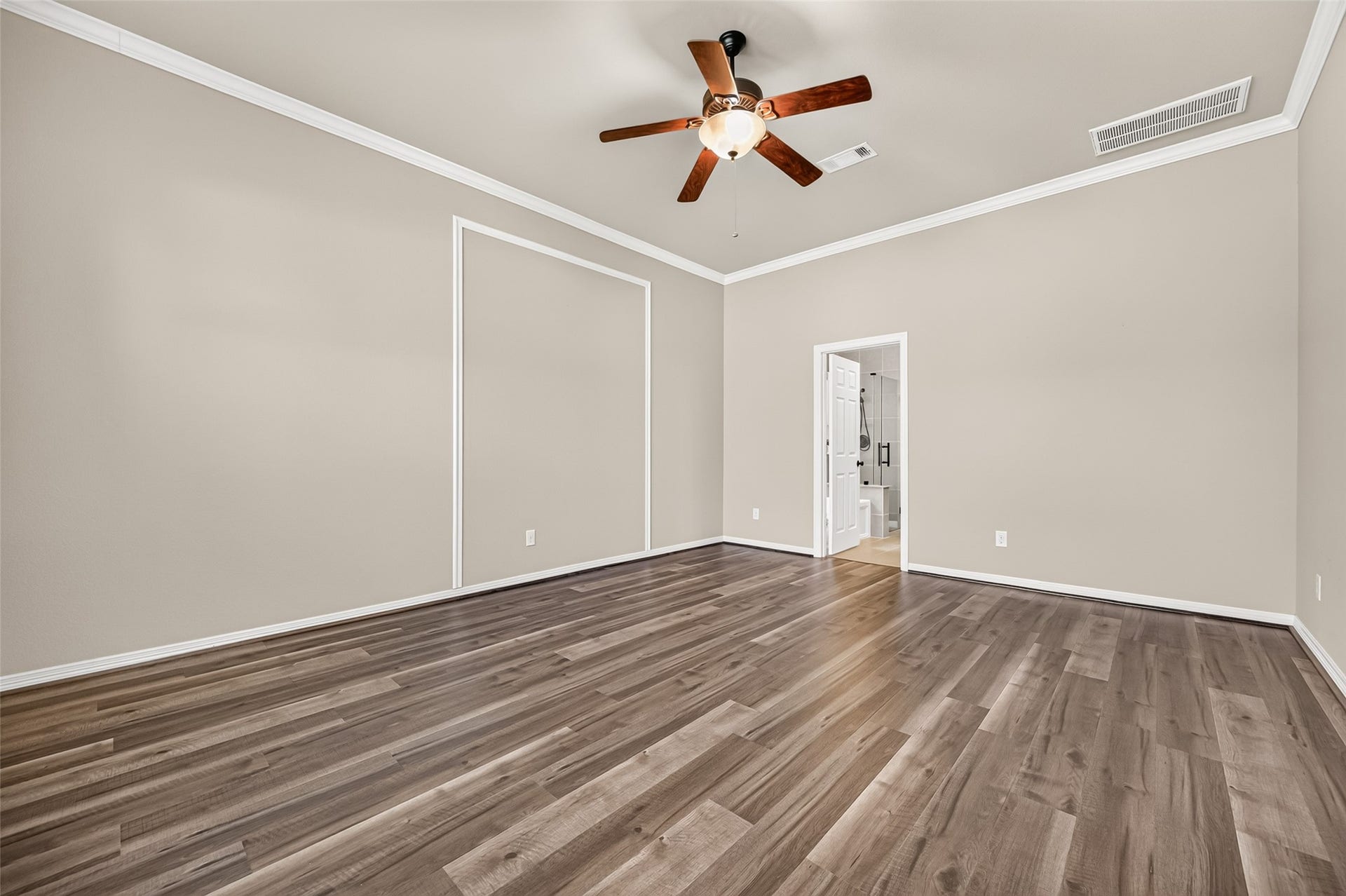 4314 Kent Ranch Court, Katy, TX 77494 Primary bedroom with crown molding and doorway to the ensuite bath.