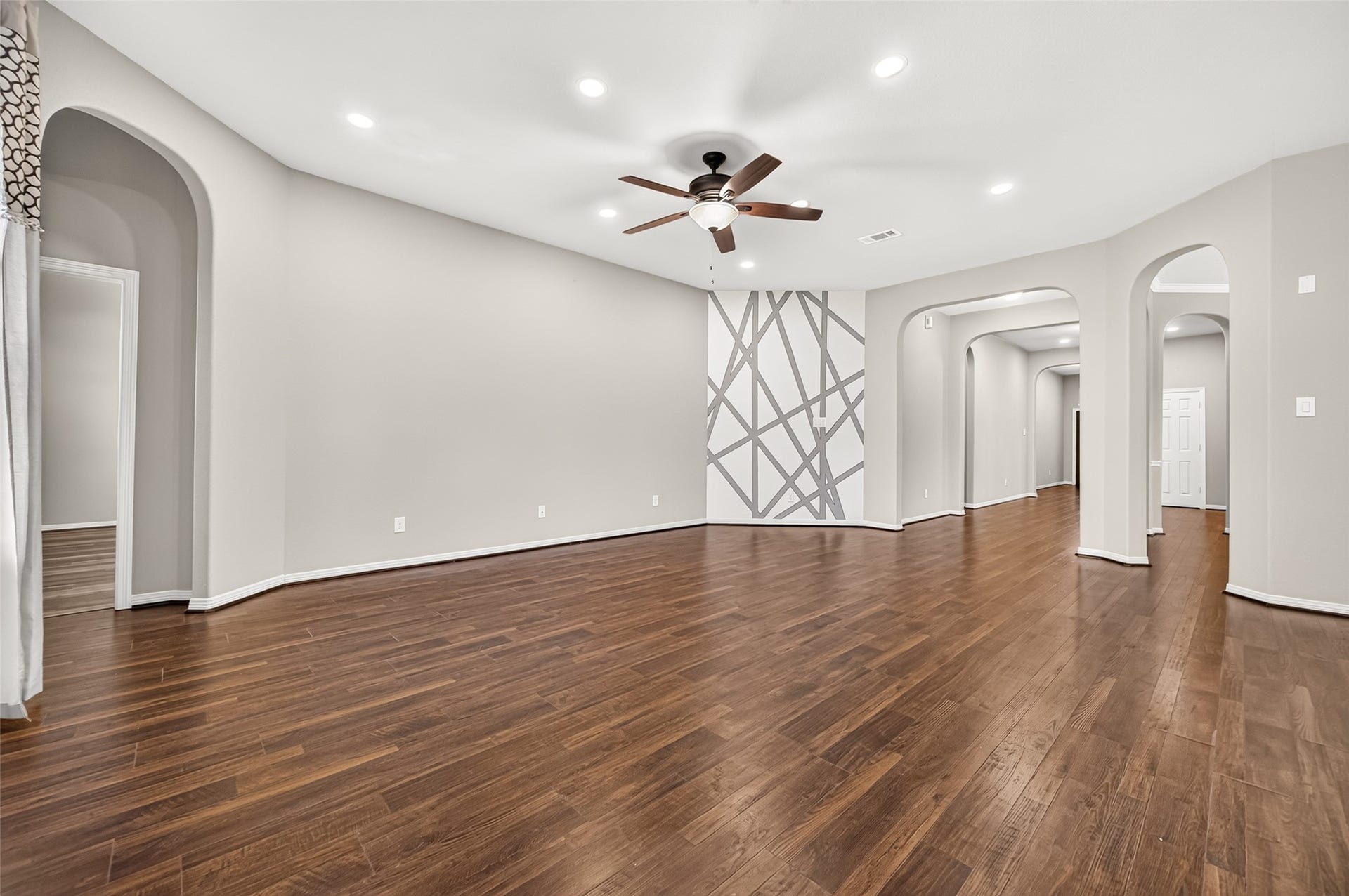 4314 Kent Ranch Court, Katy, TX 77494 Living room with arched entryways, recessed lighting and wood-look flooring.