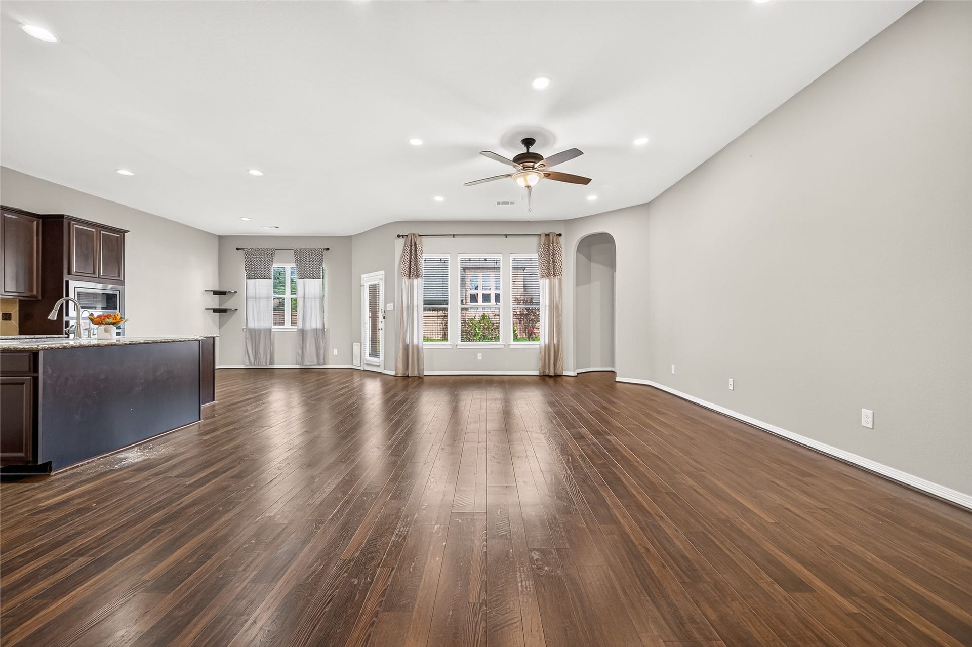 4314 Kent Ranch Court, Katy, TX 77494 Open living room flowing into the kitchen, with recessed lighting and a wall of windows.