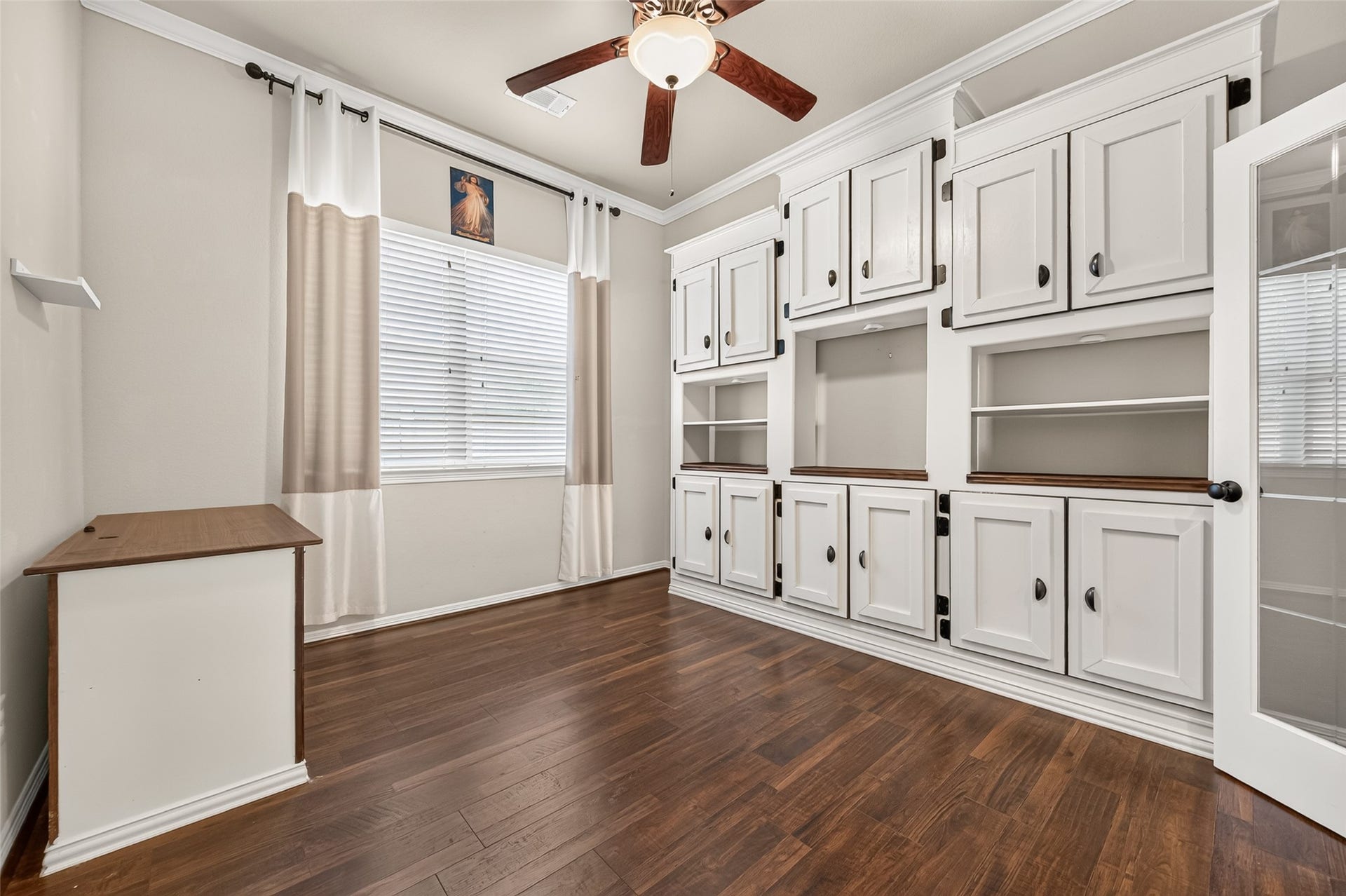 4314 Kent Ranch Court, Katy, TX 77494 Study with floor-to-ceiling built-in cabinets, open shelving, ceiling fan and large window.