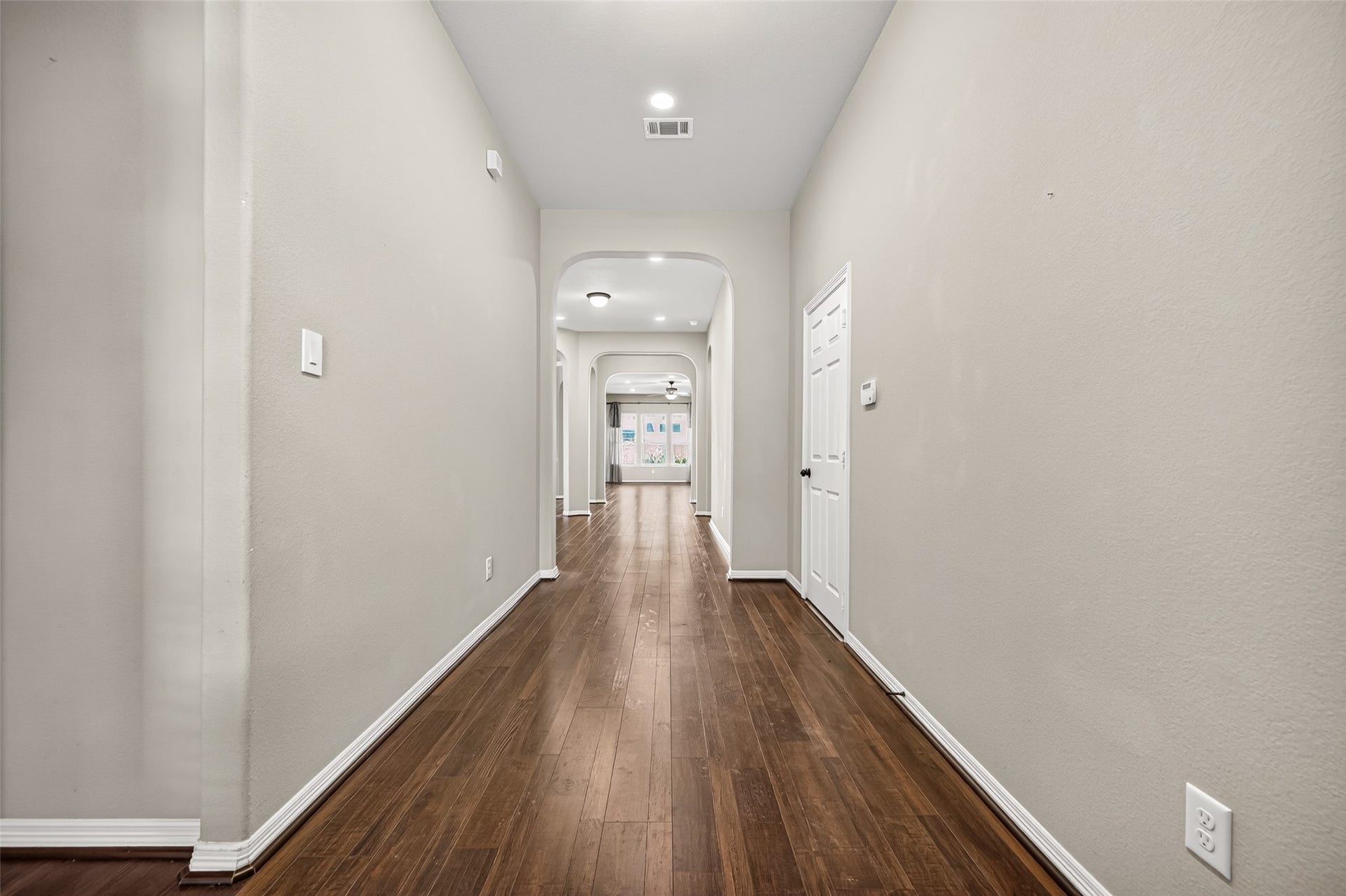 4314 Kent Ranch Court, Katy, TX 77494 Long entry hallway with wood-look flooring, recessed lighting and arched openings.