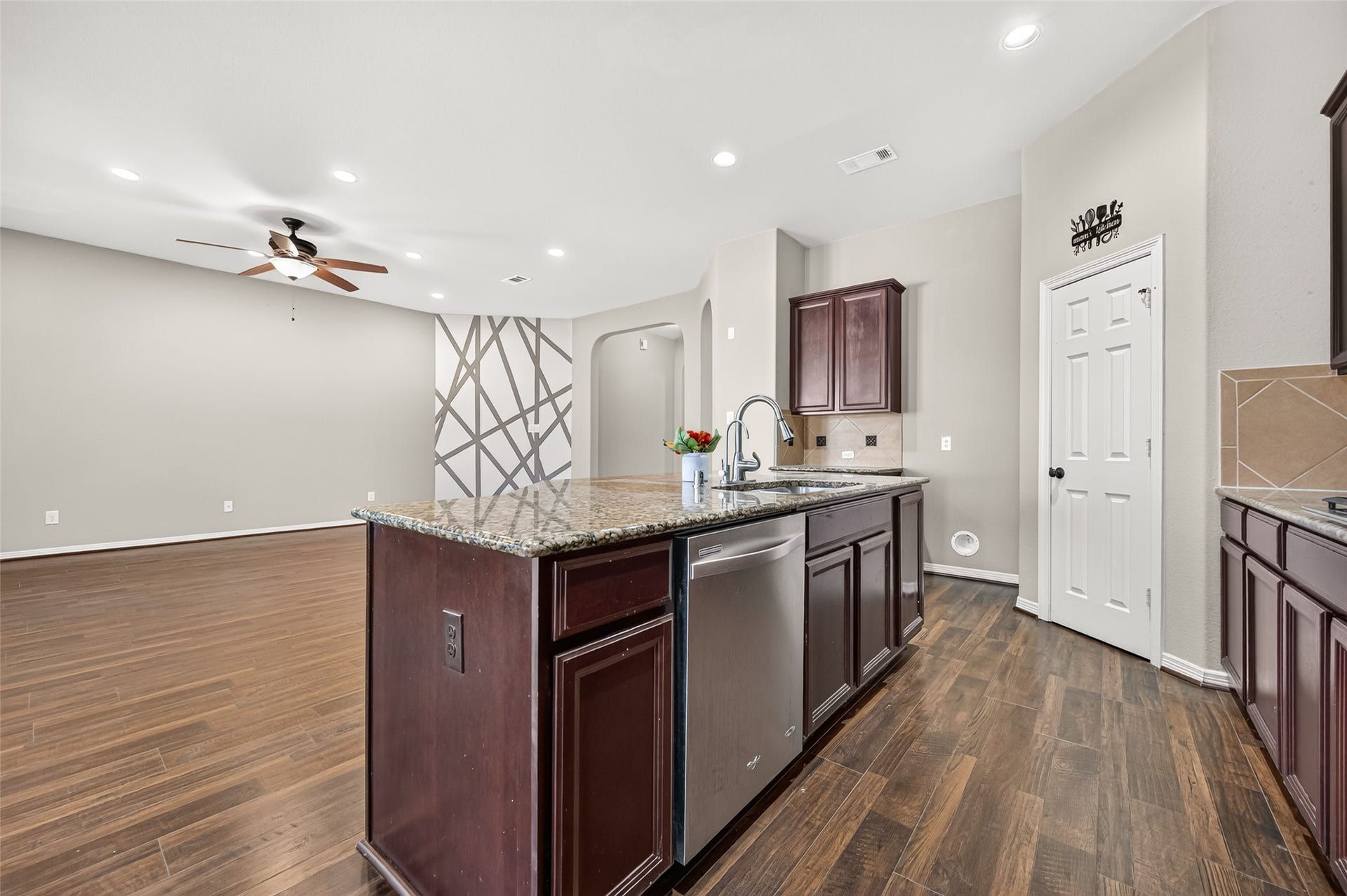 4314 Kent Ranch Court, Katy, TX 77494 Kitchen island with stainless dishwasher, overlooking the living room.