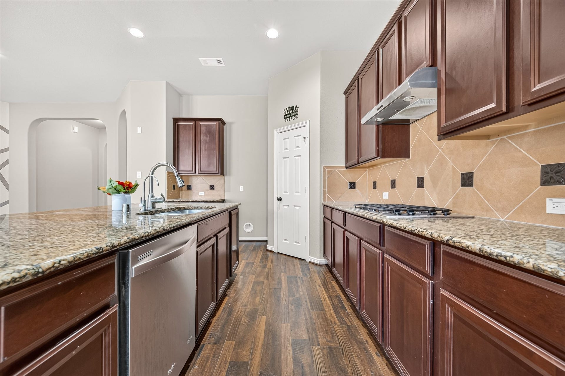 4314 Kent Ranch Court, Katy, TX 77494 Galley-style work area with granite-look counters, stainless dishwasher and diagonal tile backsplash.