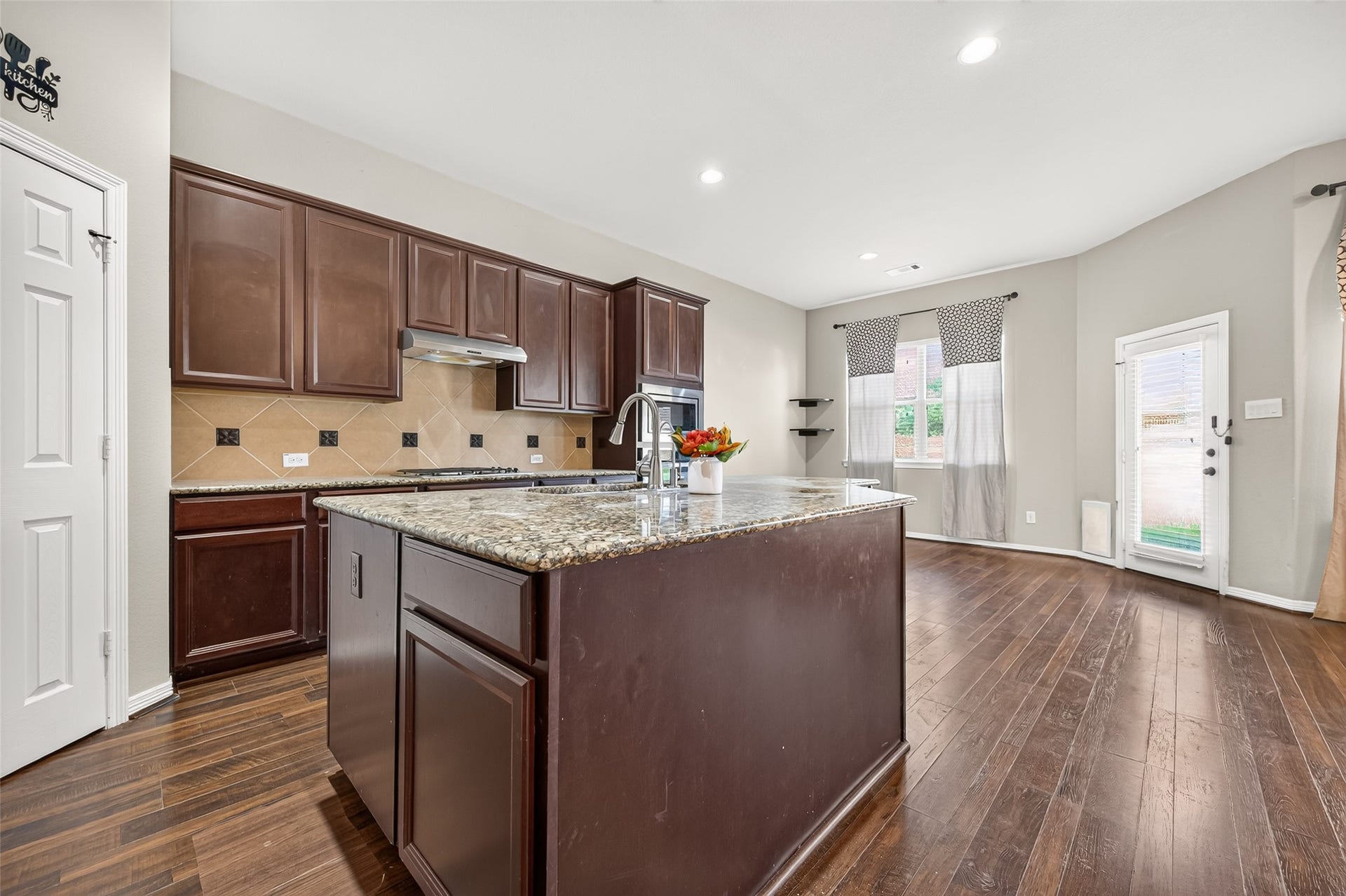 4314 Kent Ranch Court, Katy, TX 77494 Kitchen island with granite-look countertop and undermount sink, open to the breakfast area.