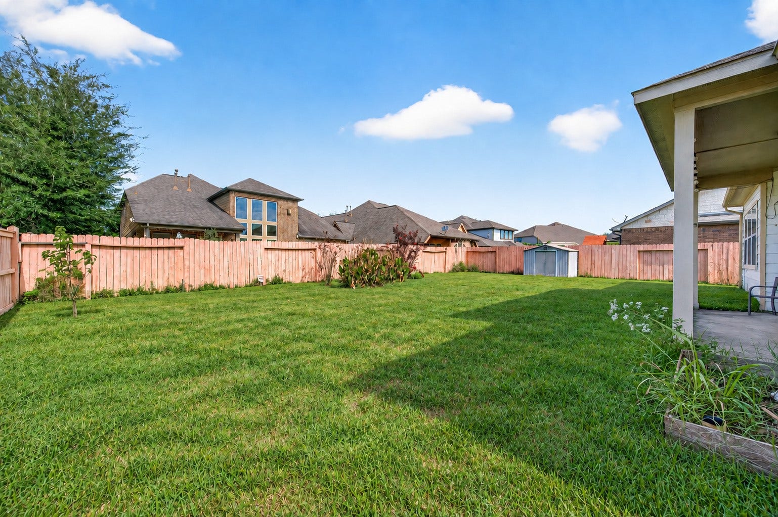 4314 Kent Ranch Court, Katy, TX 77494 Spacious backyard with wood privacy fence and open lawn.