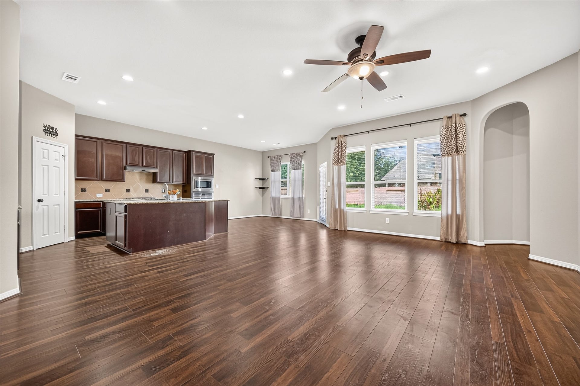 4314 Kent Ranch Court, Katy, TX 77494 Living room with three large windows, arched niche and views into the kitchen.