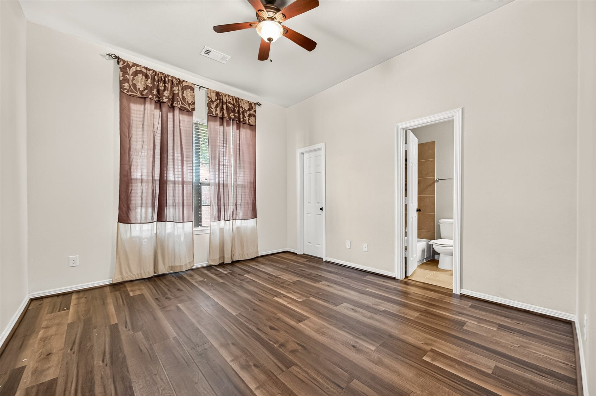 4314 Kent Ranch Court, Katy, TX 77494 Secondary bedroom with ceiling fan, two windows and an ensuite bath.