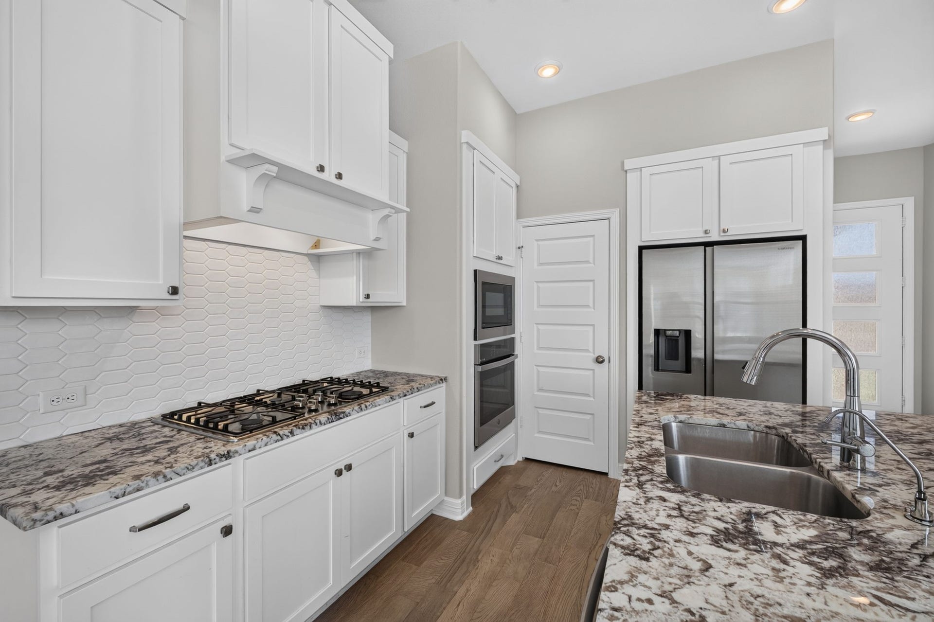 24638 Carleton Lake Lane, Tomball, TX 77375 Kitchen is gorgeous with white cabinets and beautiful granite looks looks sharp with sleek stainless steel appliances. Built in oven/microwave and gas cooktop are the perfect choices in this kitchen.