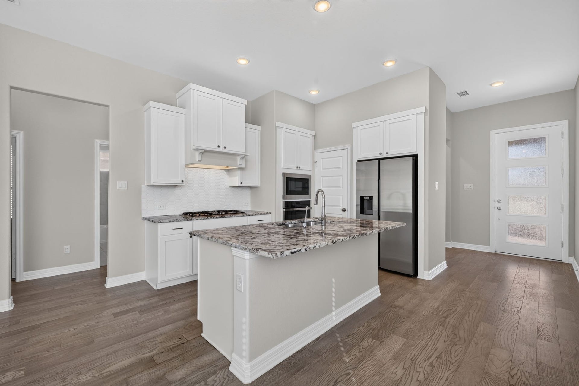24638 Carleton Lake Lane, Tomball, TX 77375 Kitchen has large central island with room for seating. Walk-in pantry located to the left of refrigerator is a convenient feature.