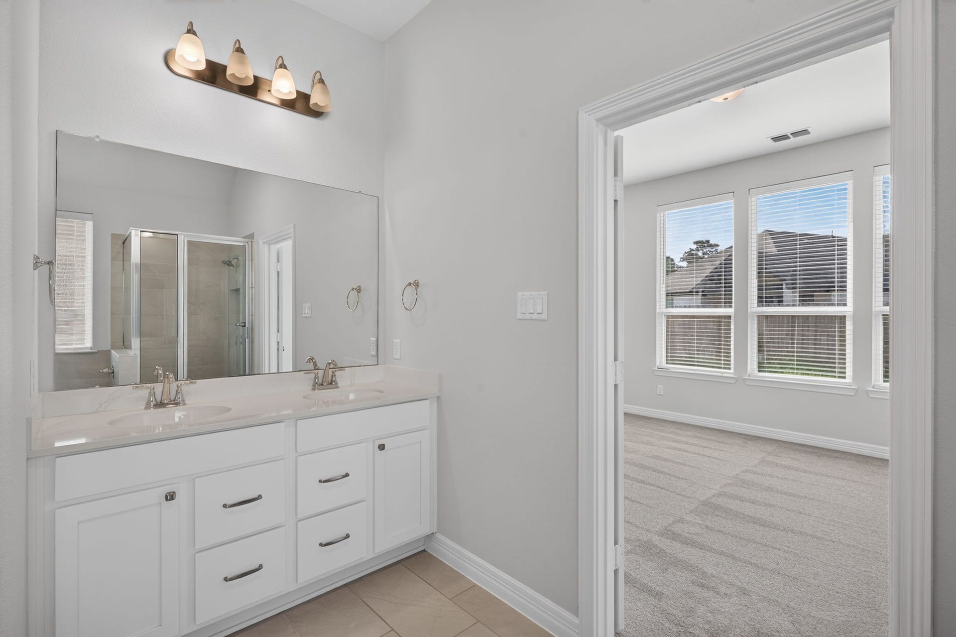 24638 Carleton Lake Lane, Tomball, TX 77375 Primary bath has convenient dual vanities with silver fixtures, a highly desirable feature in primary bathrooms.