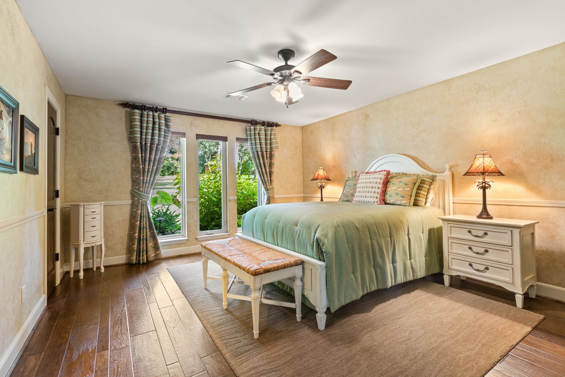 23107 Kobs Road, Tomball, TX 77377 This inviting secondary bedroom boasts hardwood floors, a ceiling fan, abundant natural light, and garden views through large windows. Includes an ensuite bathroom.
