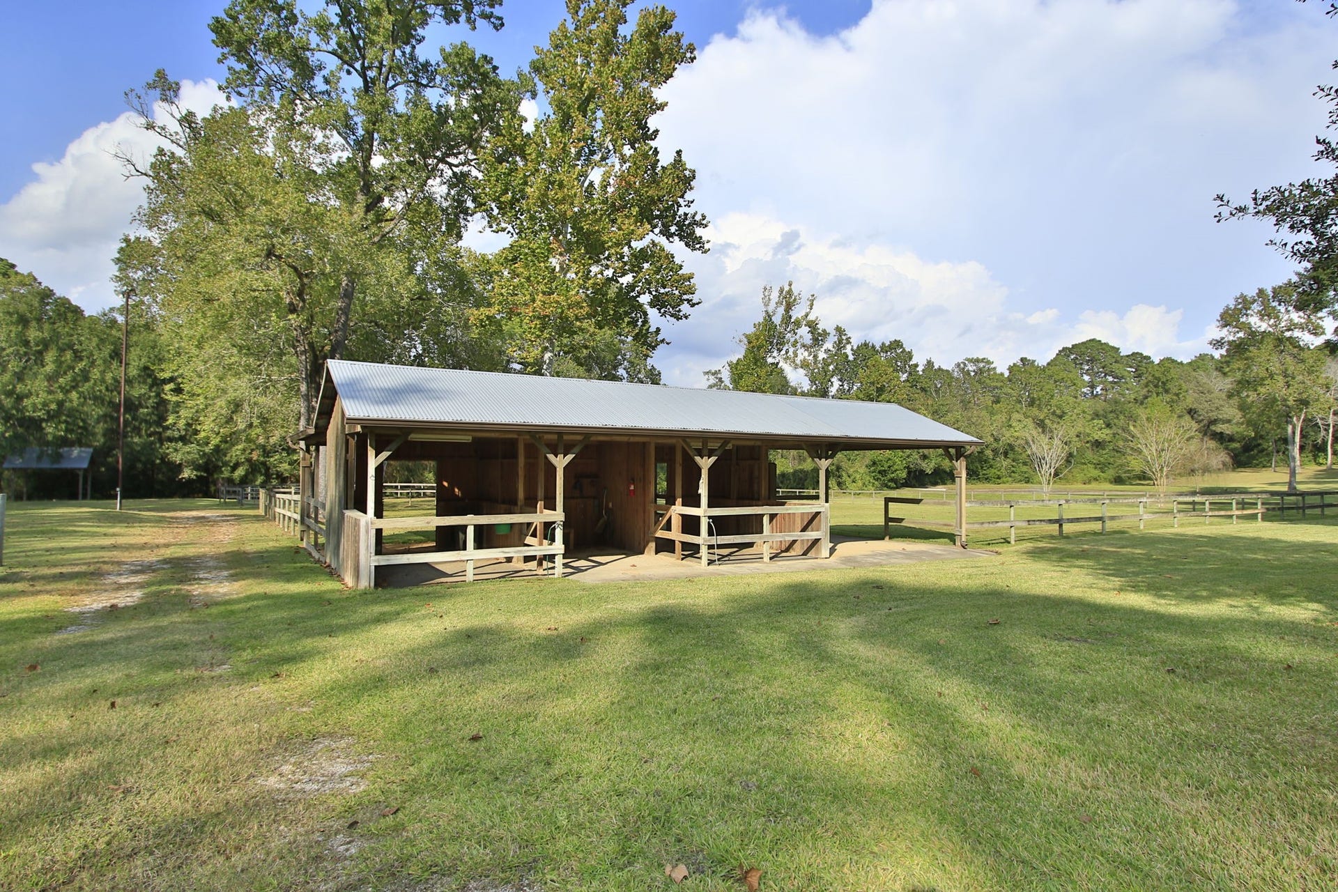 23107 Kobs Road, Tomball, TX 77377 Charming barn with a metal roof set in a spacious, grassy area surrounded by mature trees. Ideal for the horse enthusiast and storage.