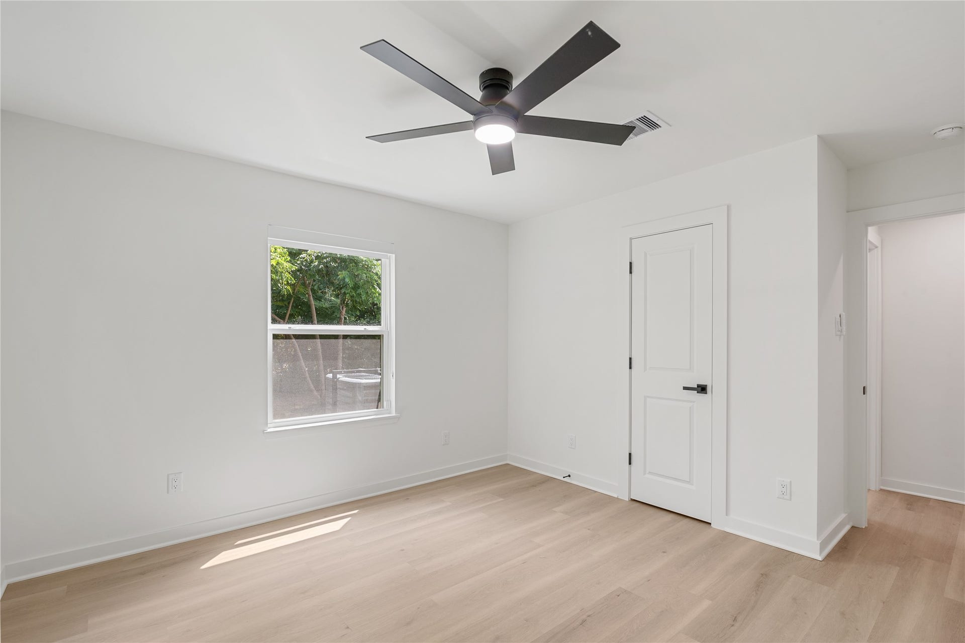 703 Newton Drive, Richmond, TX 77469 Another angle of the bedroom highlighting the natural light, modern ceiling fan, and access to the adjoining hallway.