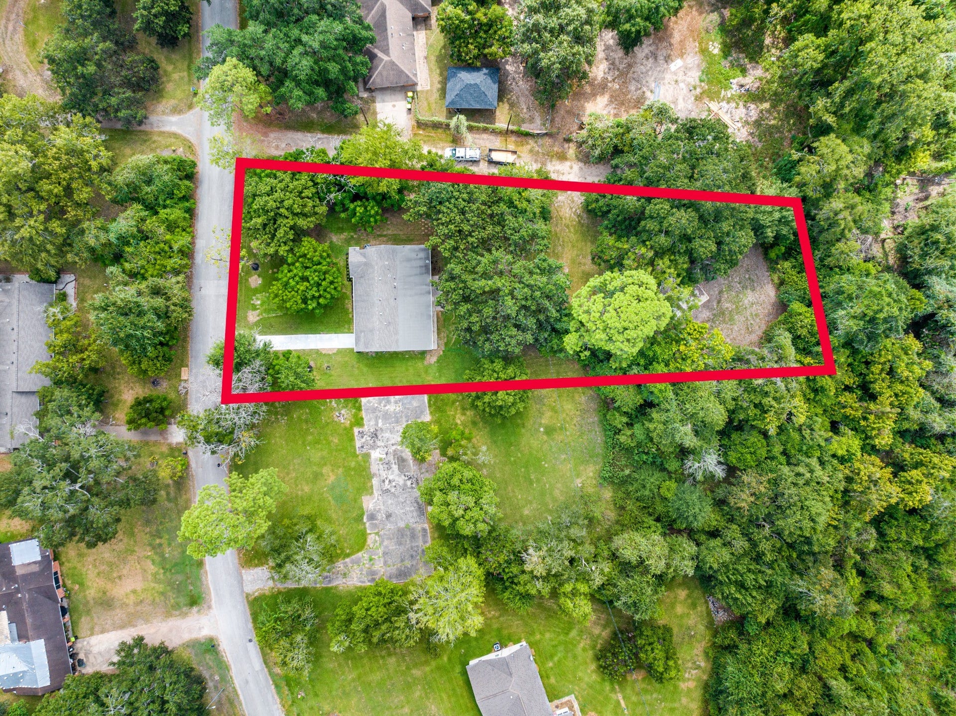 703 Newton Drive, Richmond, TX 77469 Top-down aerial view with approximate property boundaries outlined in red, illustrating the full scale and configuration of the nearly one-acre parcel.