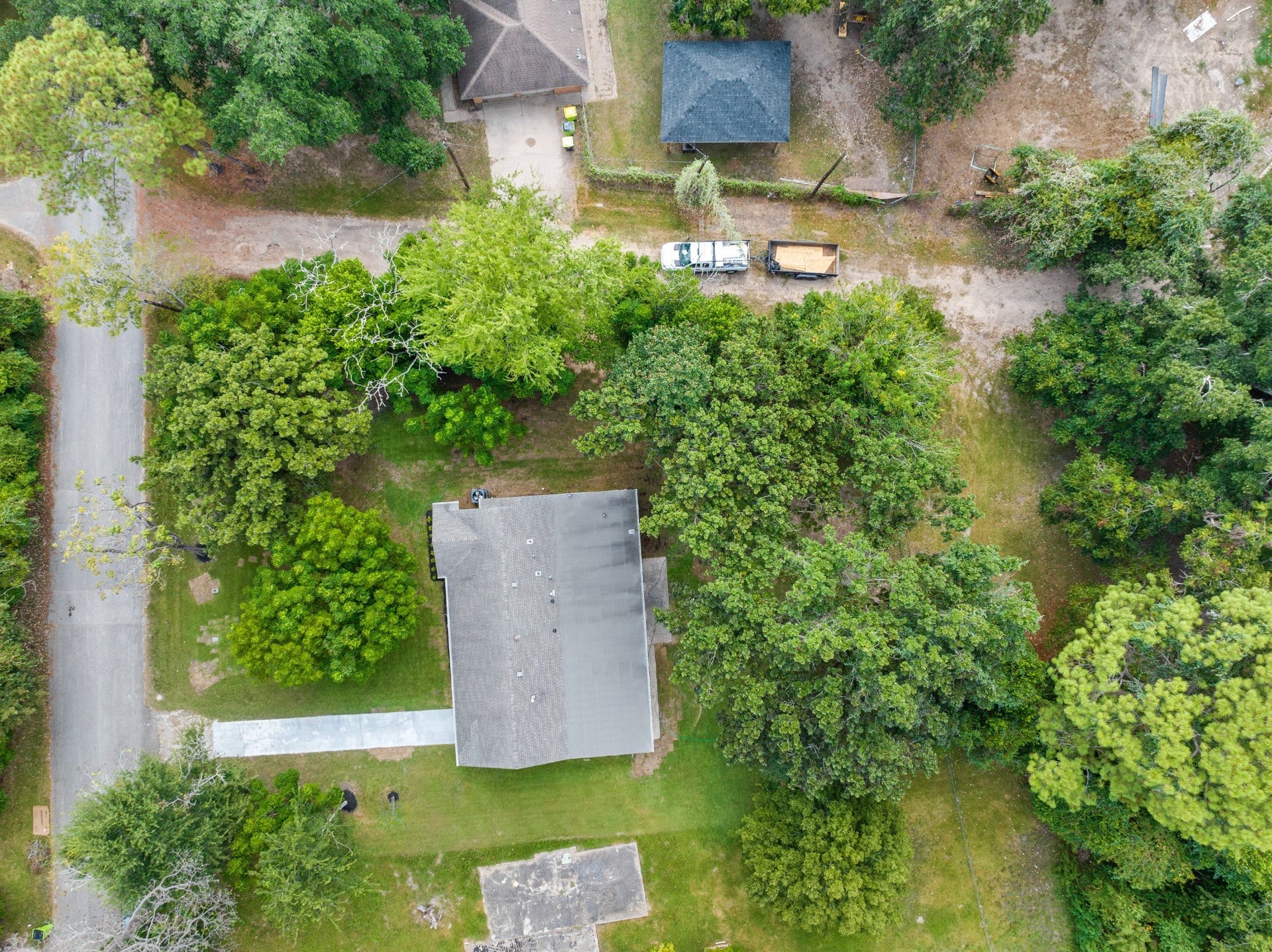 703 Newton Drive, Richmond, TX 77469 Straight-down aerial view showing the home's placement within the lot, surrounded by mature trees and expansive green space.