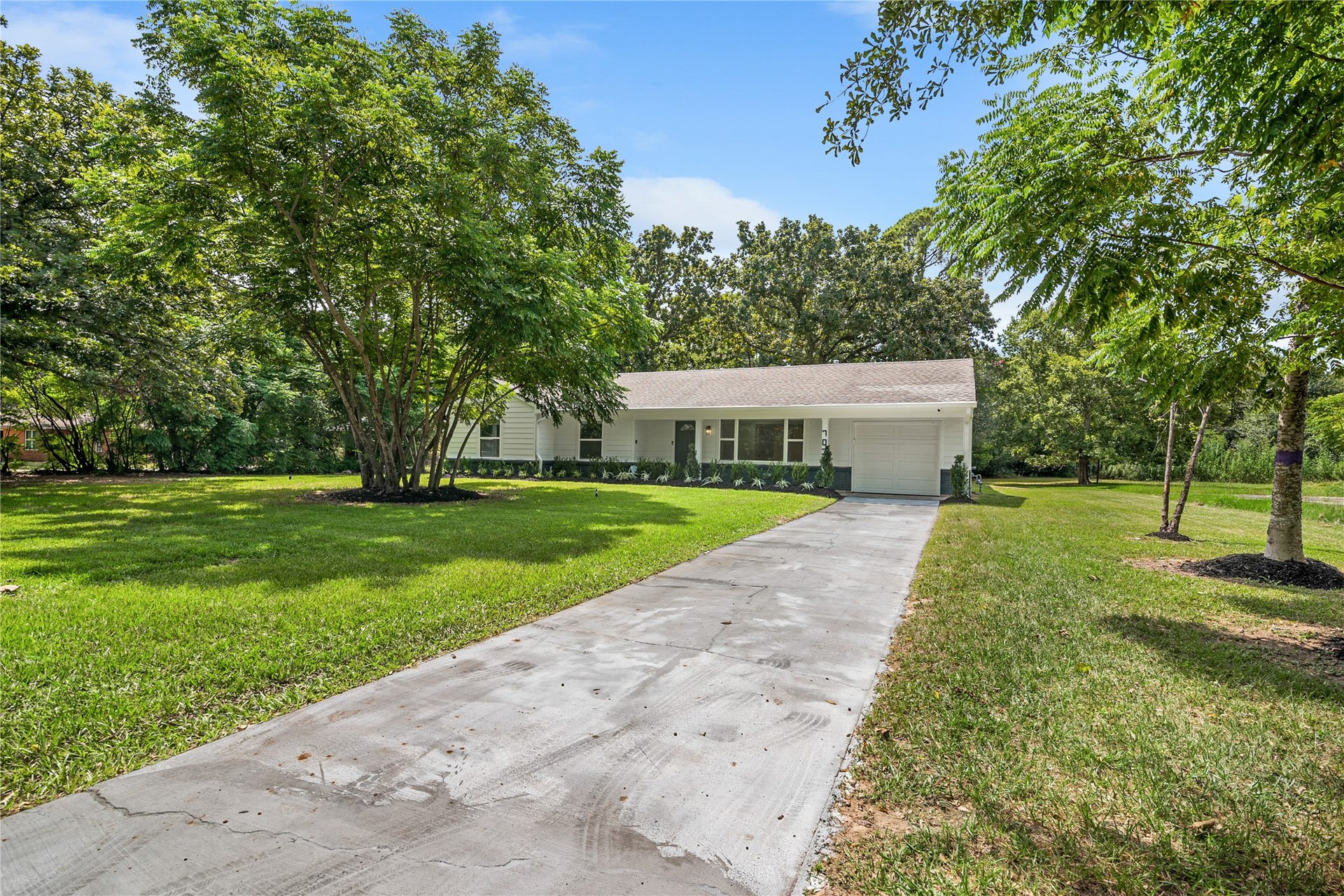 703 Newton Drive, Richmond, TX 77469 Long driveway leads to the home through a beautifully shaded property with mature trees and abundant green space.
