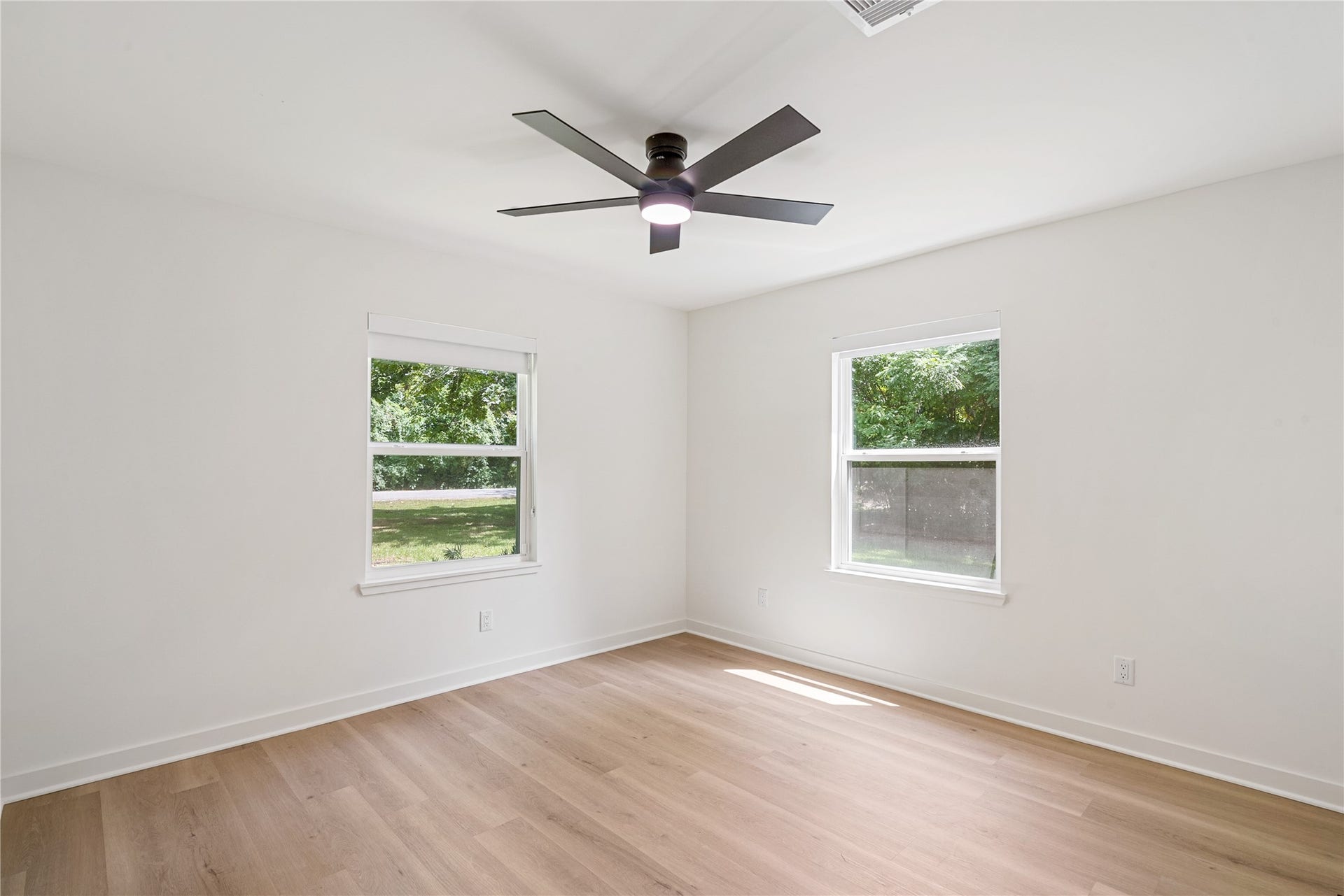 703 Newton Drive, Richmond, TX 77469 Bright bedroom featuring two windows, updated flooring, recessed lighting, and a contemporary ceiling fan.