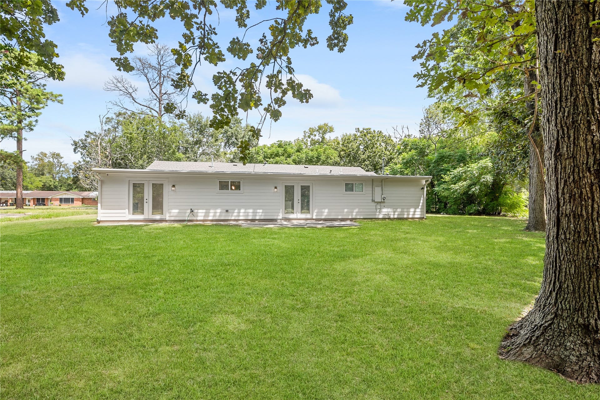 703 Newton Drive, Richmond, TX 77469 Expansive green lawn and mature shade trees create a beautiful setting around this renovated single-story home.