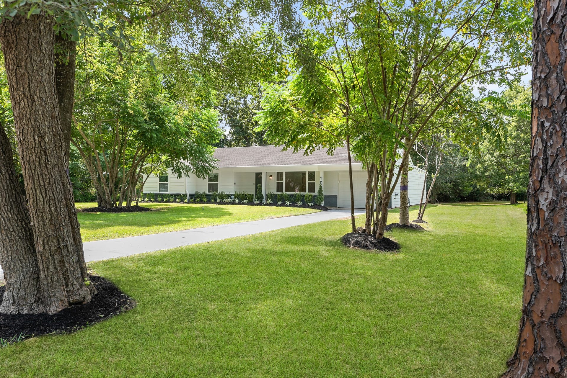 703 Newton Drive, Richmond, TX 77469 Mature shade trees frame the welcoming approach to the home, offering an attractive setting with plenty of outdoor space.