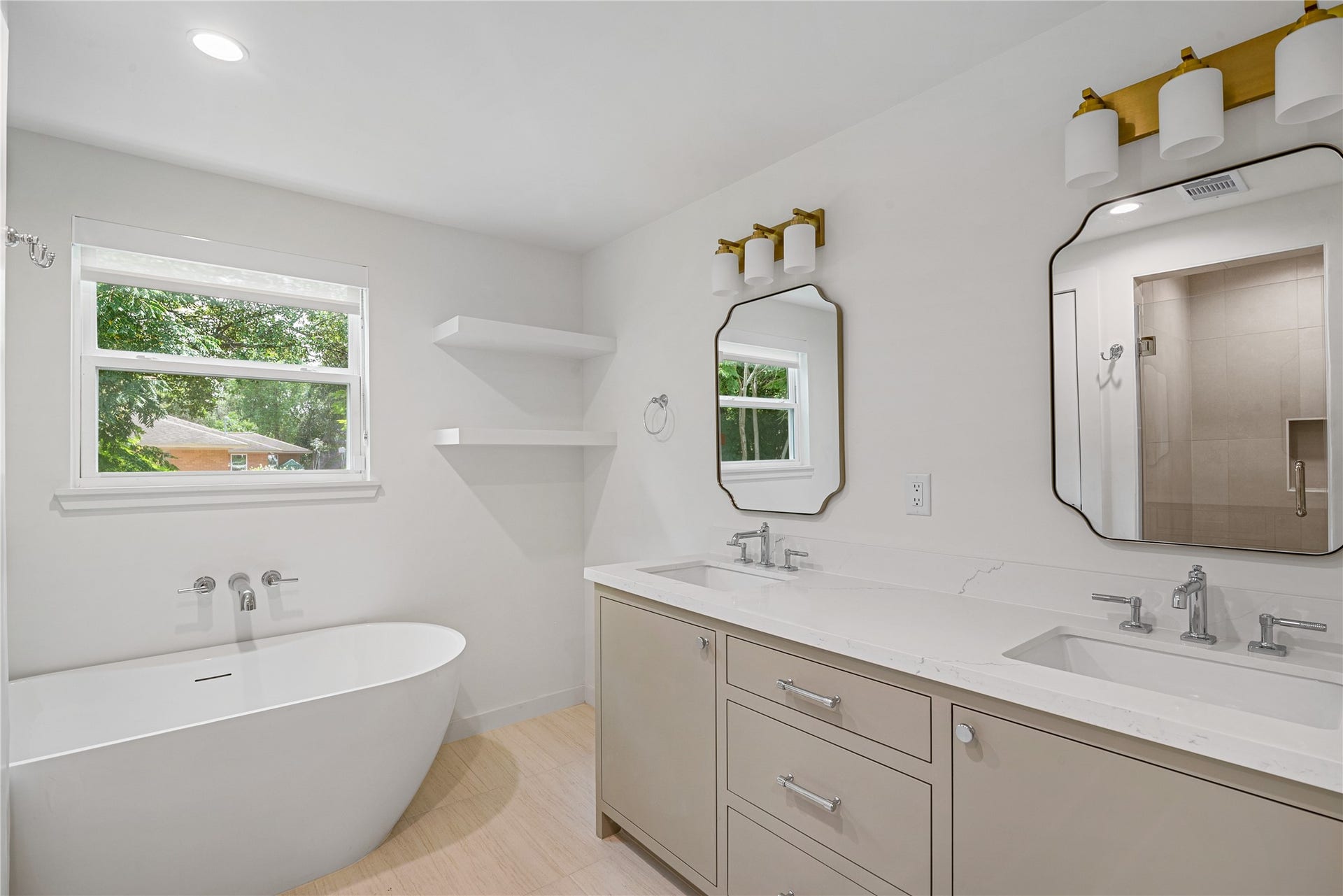 703 Newton Drive, Richmond, TX 77469 Beautifully renovated bathroom featuring a freestanding soaking tub, separate tiled shower, dual-sink vanity, and stylish modern fixtures.
