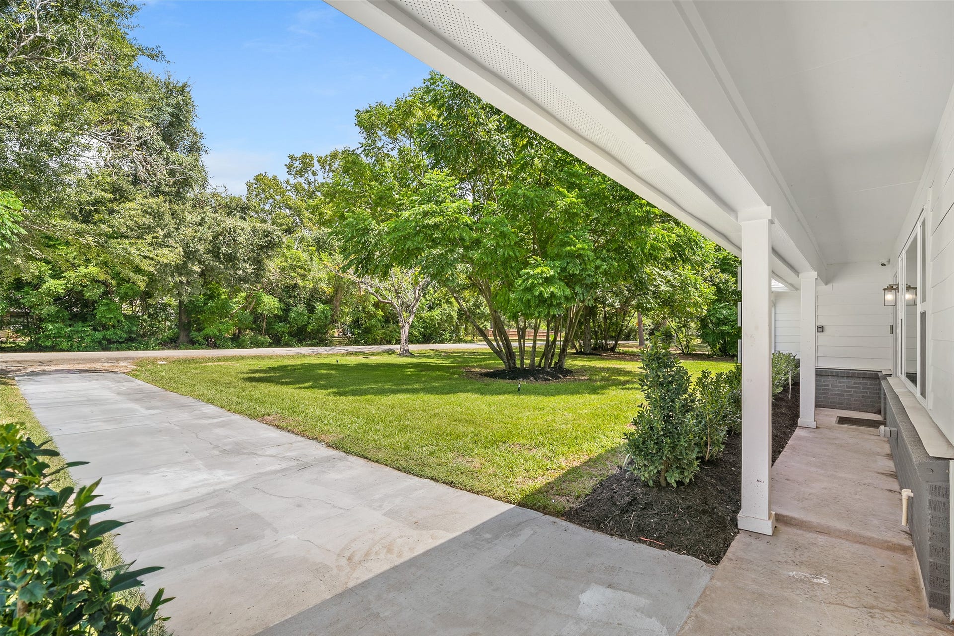 703 Newton Drive, Richmond, TX 77469 Covered area alongside the home offers a sheltered transition to the driveway and surrounding outdoor space.