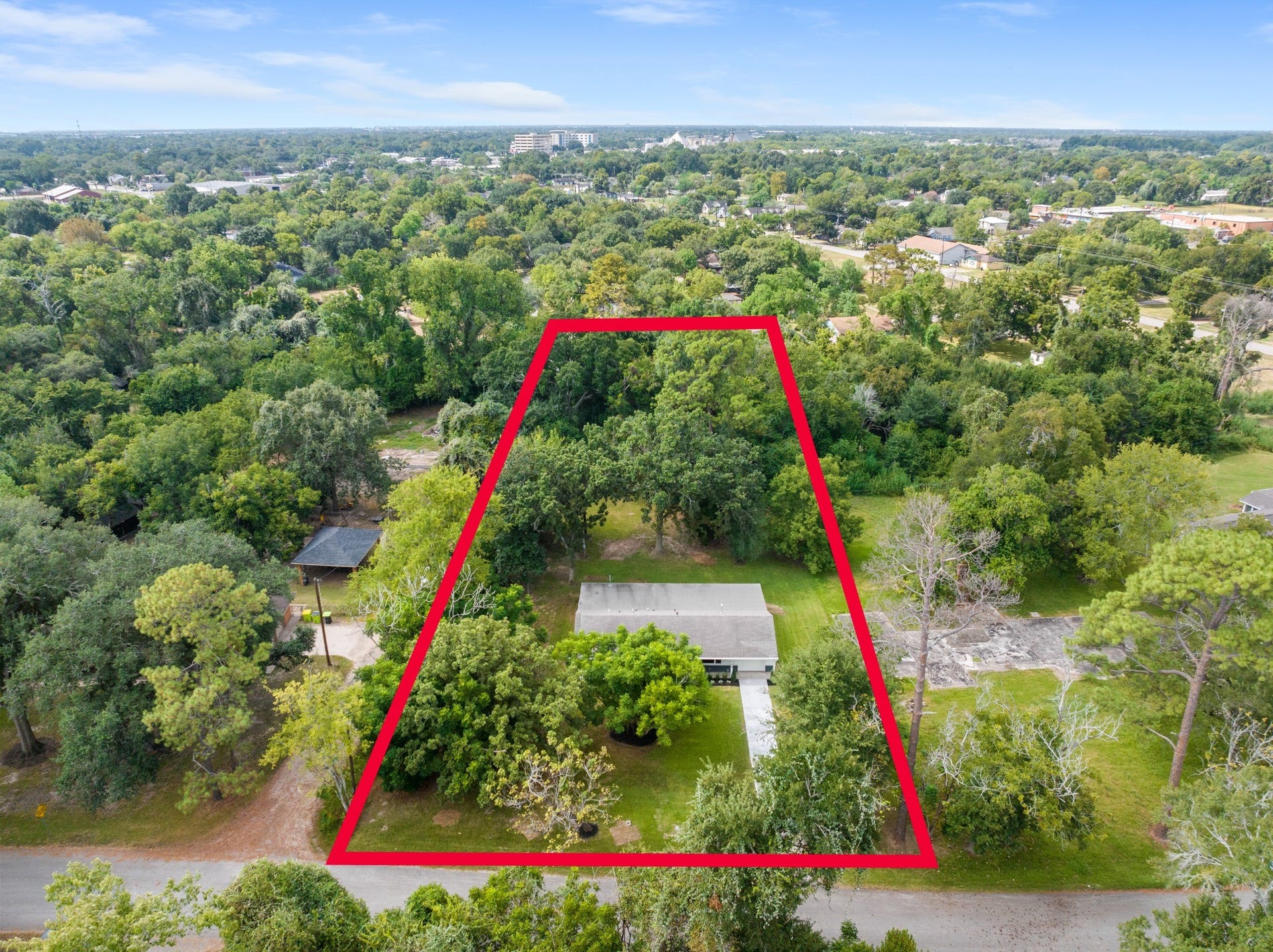 703 Newton Drive, Richmond, TX 77469 Aerial view with approximate property boundaries outlined in red, illustrating the impressive depth of the nearly one-acre lot.