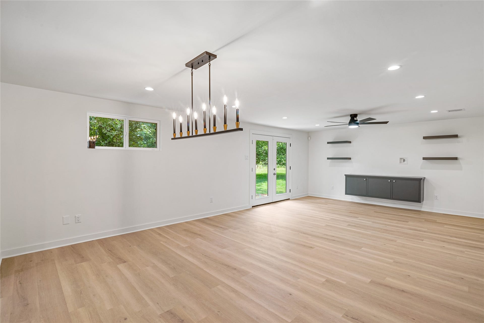703 Newton Drive, Richmond, TX 77469 Bright, open living and dining areas feature updated flooring, recessed lighting, and a modern chandelier.
