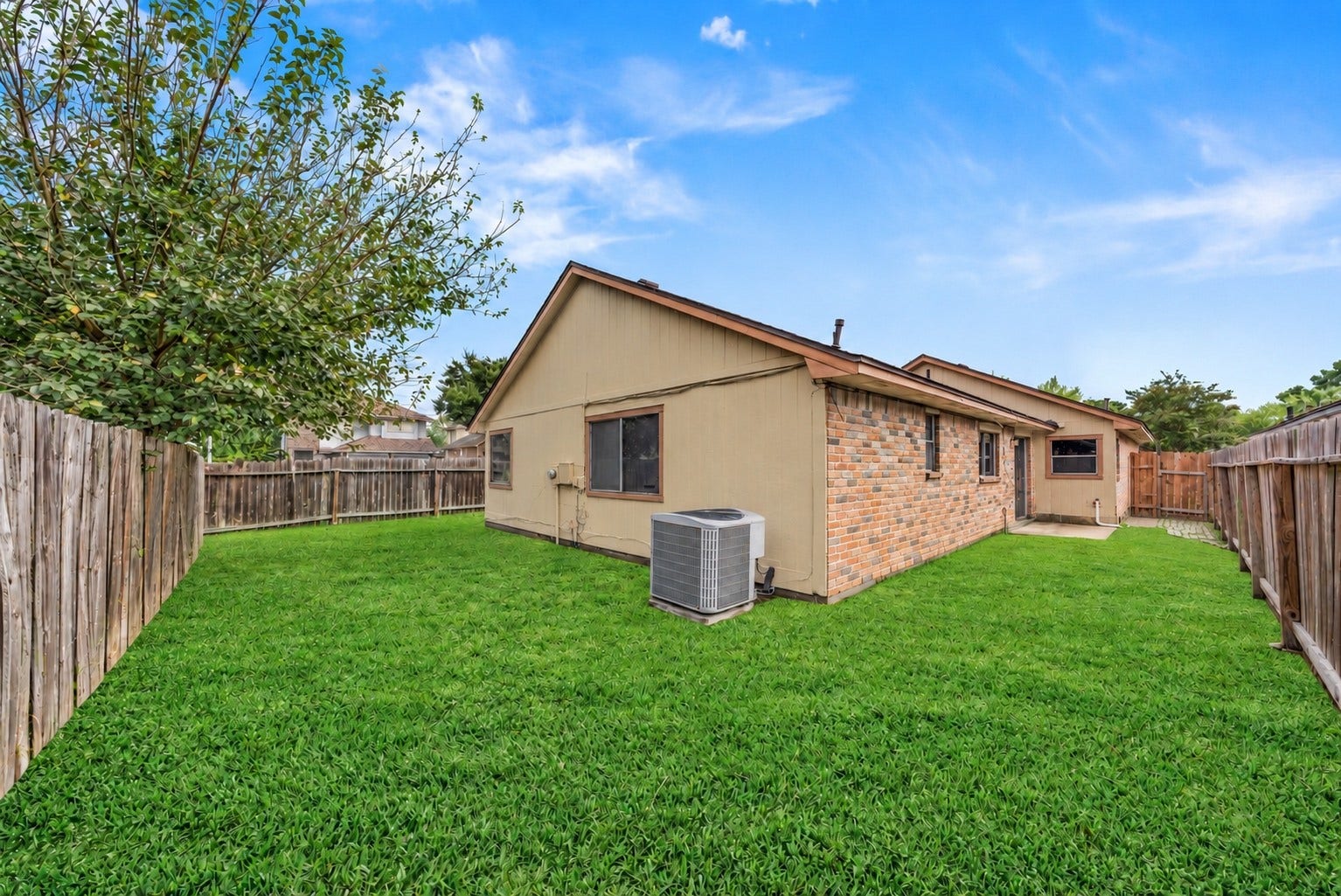 Green grass fills the fully fenced backyard, with a wood privacy fence on every side. The air conditioning unit sits against the back of the home, and the lawn runs along the side of the house to the patio by the Dining Area. A large tree in the corner shades part of the yard, and the grass runs right up to the fence line. Tallow Wood Community Park, with the HOA pool, a walking track and a dog park, is about a 6-minute walk. For dinner out, Vintage Park is about 2.4 miles away.