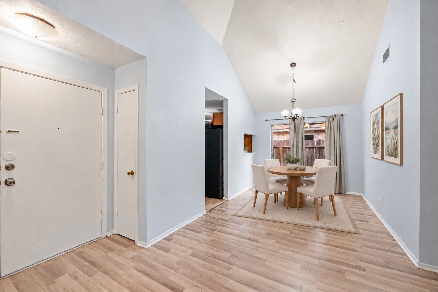 Through the front door, a small Foyer leads straight to the Dining Area and the sliding glass door to the backyard. A coat closet sits right beside the front door. The Dining Area (10'7" x 9'1") holds a table for four or more under the hanging light fixture, and the Kitchen doorway is just to the left. A wall opening between the Kitchen and Dining Area makes serving easy. Wood-look floors run from the front door to the back door. Virtually staged.