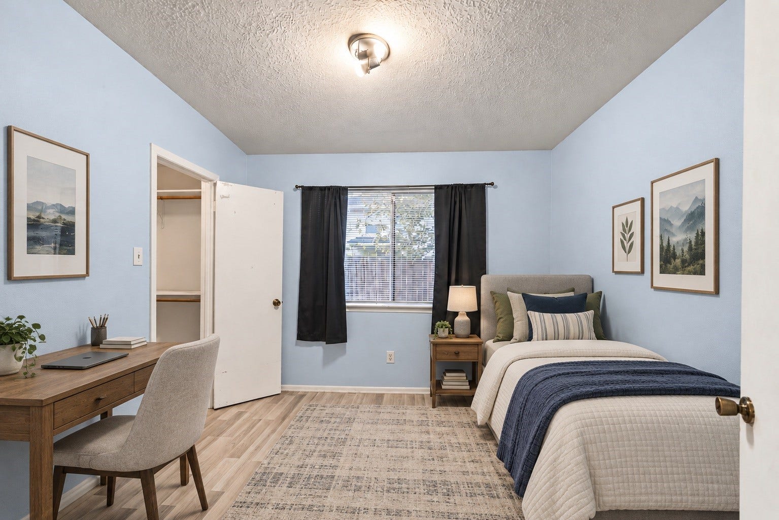 Set up here with a bed and a desk, this Secondary Bedroom (10'3" x 10'2") fits a work area along the left wall with room to spare. Framed art and a dark throw on the bed show one way to style it. This is the bedroom with its own walk-in closet (5'4" x 5'6"), a nice extra for a secondary room. The window on the far wall brings in daylight. A ceiling light is centered overhead, and wood-look flooring runs through. The room opens off the bedroom hall. Virtually staged.