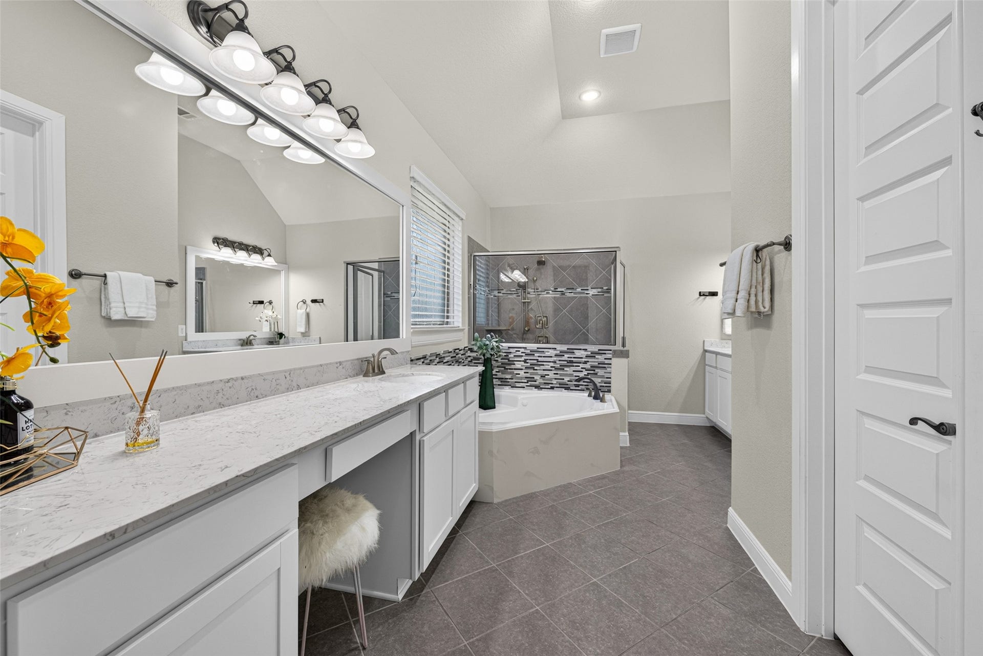 5811 Caper Shores Lane, Sugar Land, TX 77479 Spacious primary en-suite bathroom featuring a long vanity, expansive mirror, and a deep soaking tub.