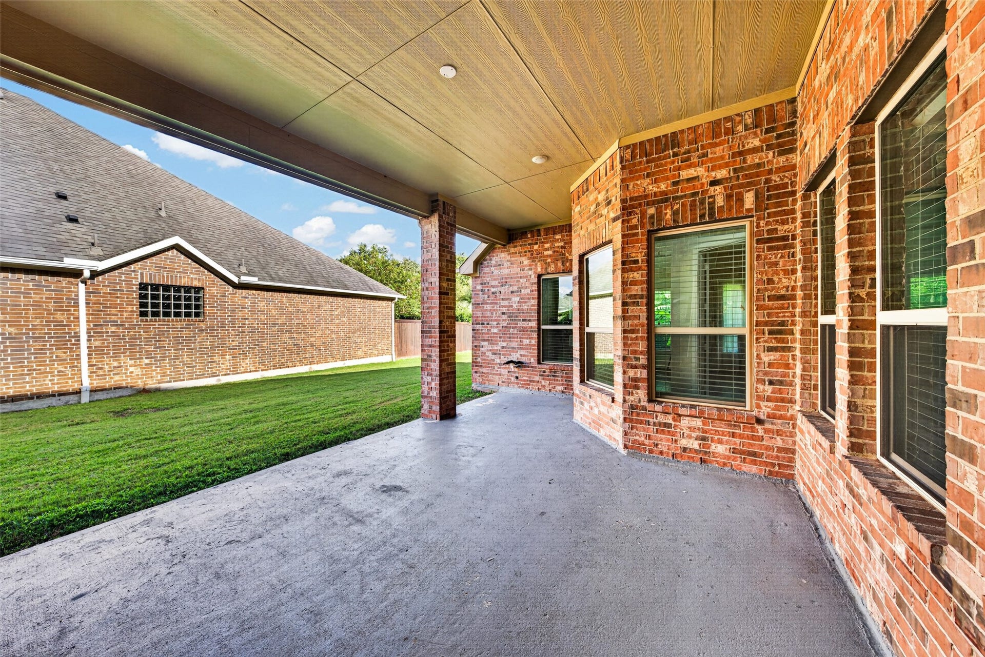 5811 Caper Shores Lane, Sugar Land, TX 77479 Covered back patio running along the side of the home, ideal for outdoor lounge seating.