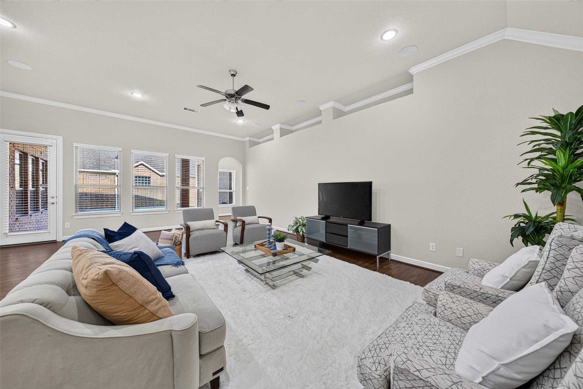 5811 Caper Shores Lane, Sugar Land, TX 77479 Bright and inviting living room with wood flooring, expansive windows, and easy access to the backyard.
