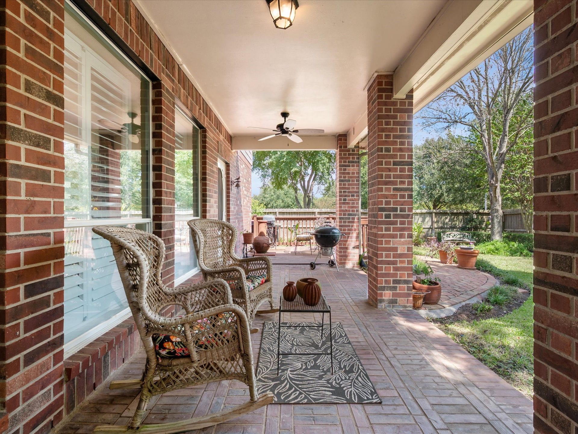 1834 Lake Quitman Drive, Richmond, TX 77406 Another look at the expansive rear covered patio, complete with dual ceiling fans, wicker seating, and an open view to the deck and backyard beyond.