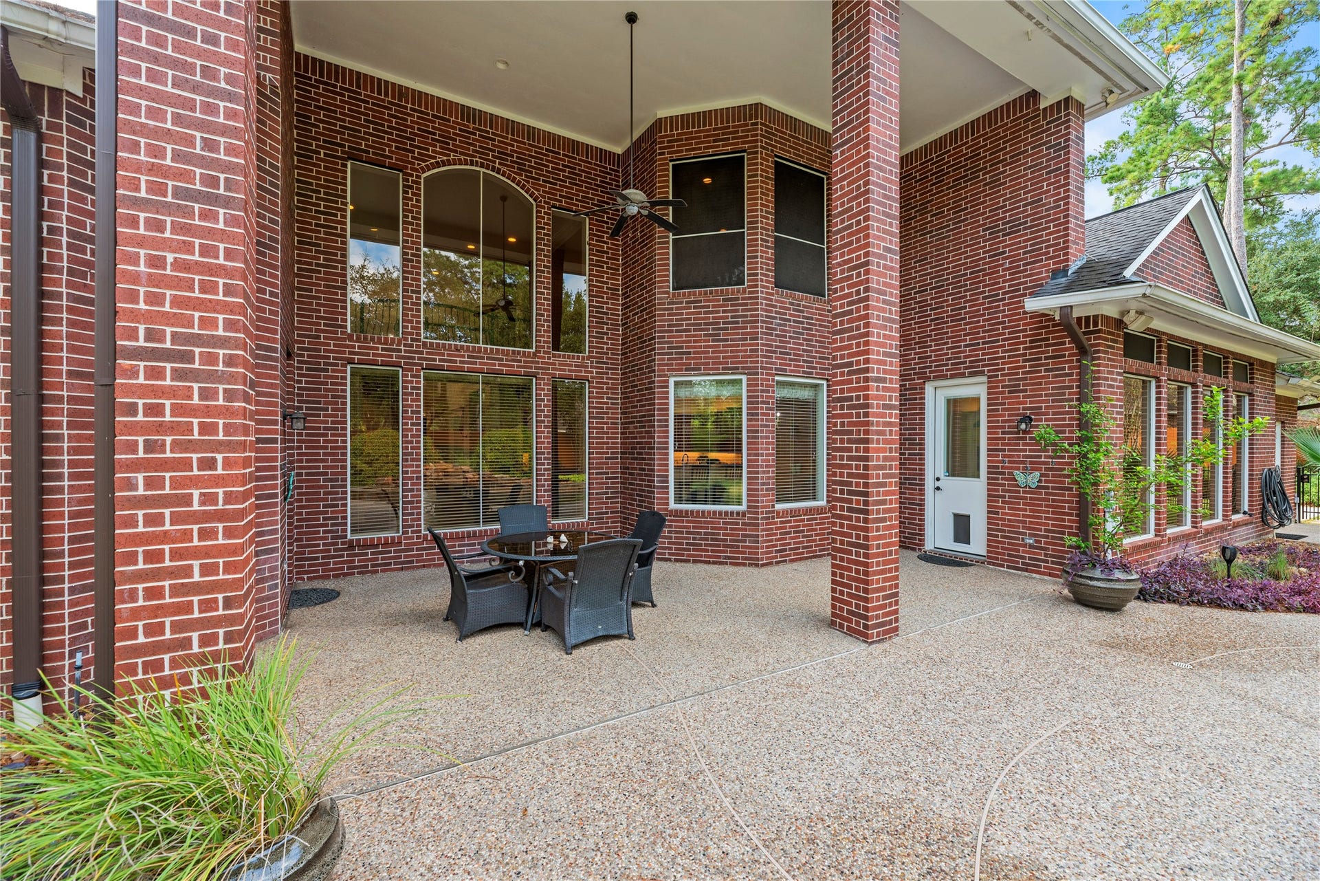 13915 Springmint Drive, Cypress, TX 77429 Expansive covered patio with soaring ceilings, stately brick columns, and an outdoor living area, offering a beautiful setting for al fresco dining and relaxation.