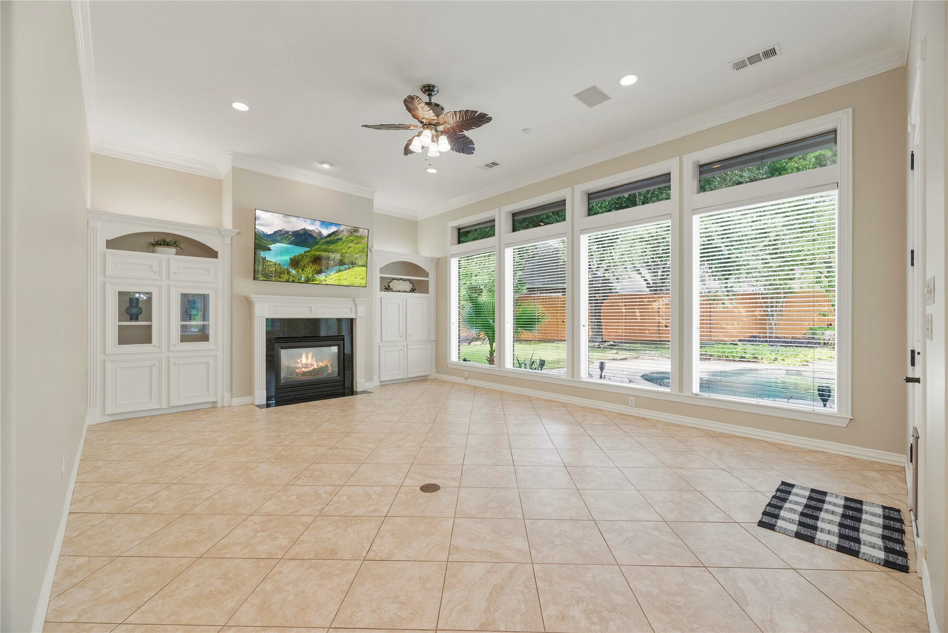 13915 Springmint Drive, Cypress, TX 77429 Family room offers tile flooring, a cozy fireplace surrounded by custom built-ins and a wall of windows with backyard views.