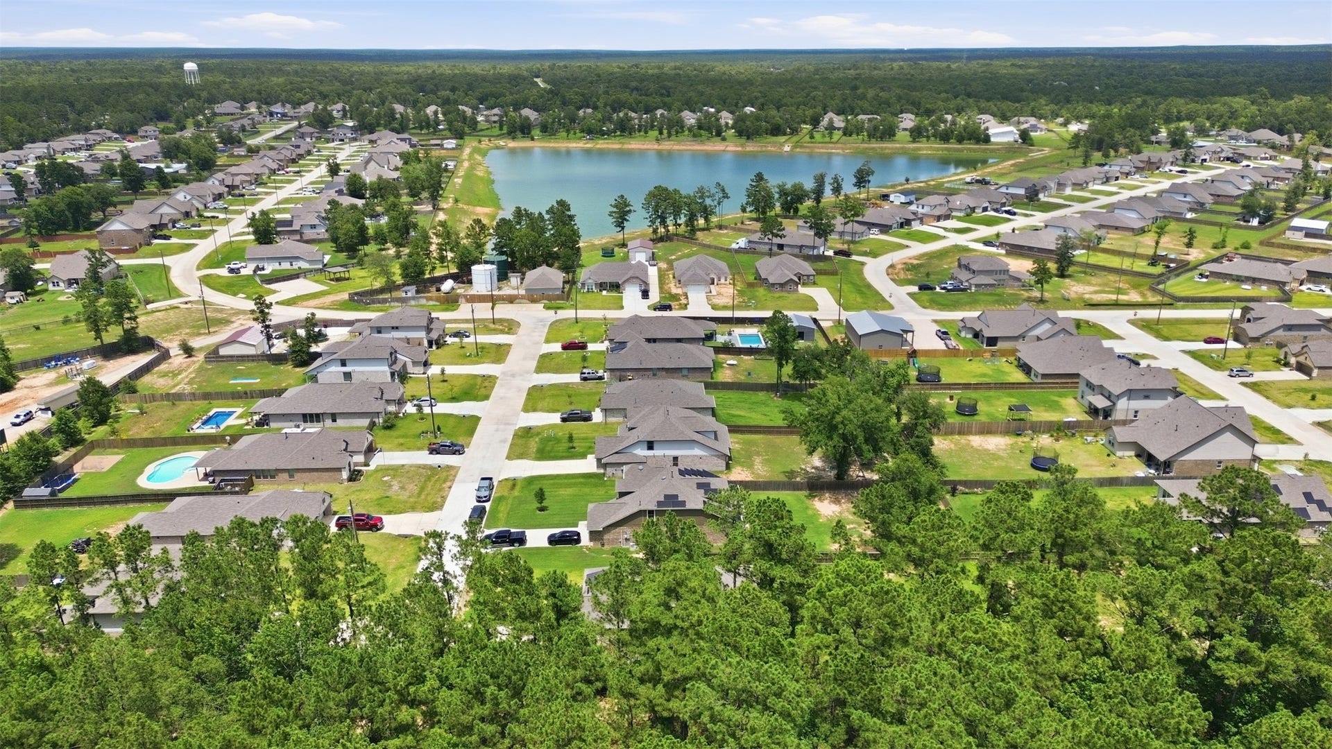 Beautiful community setting featuring a scenic pond, spacious homesites, and lush green surroundings, creating a peaceful and inviting atmosphere.