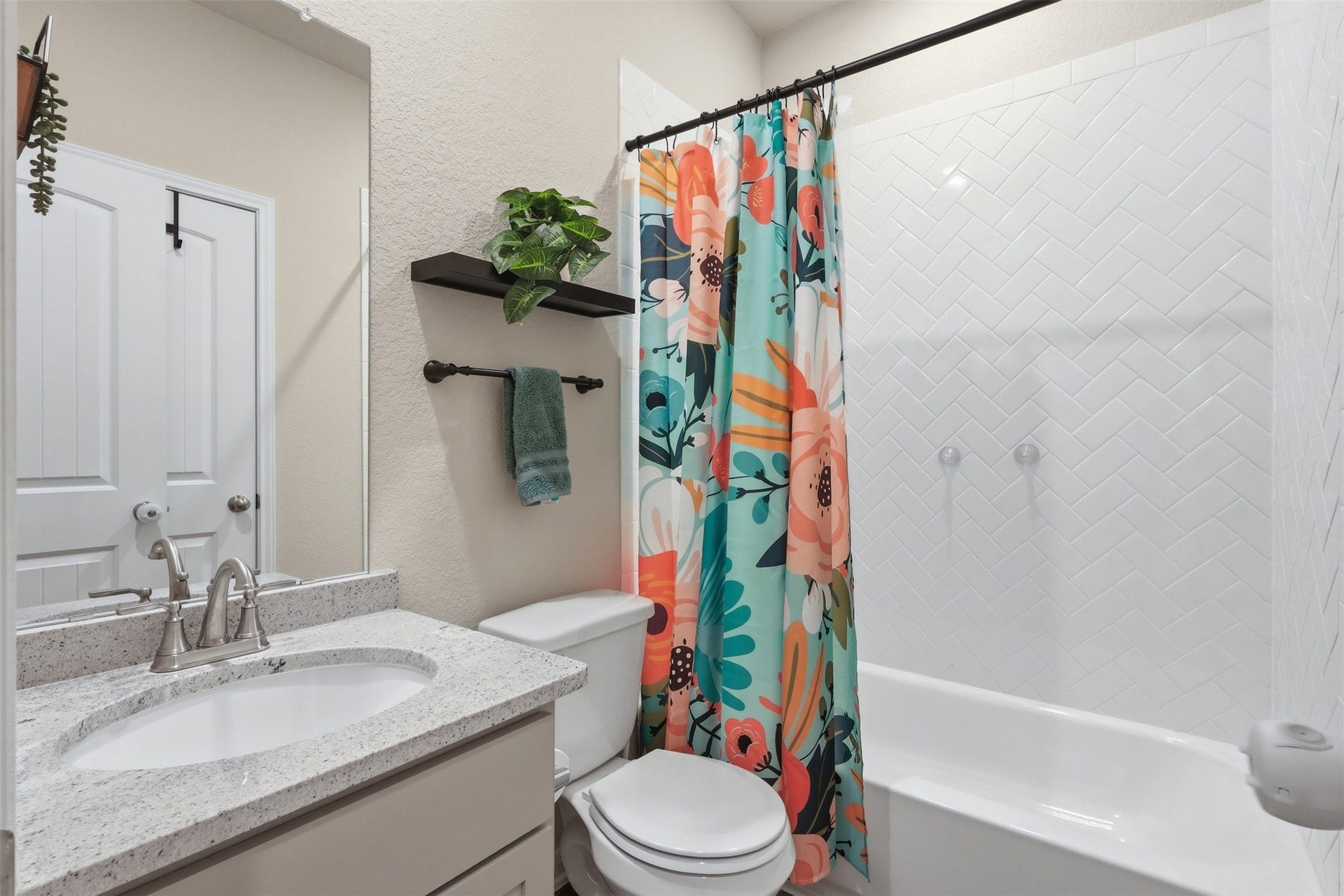Full first-floor bathroom featuring a granite vanity, modern finishes, and a tub/shower combination for added convenience.