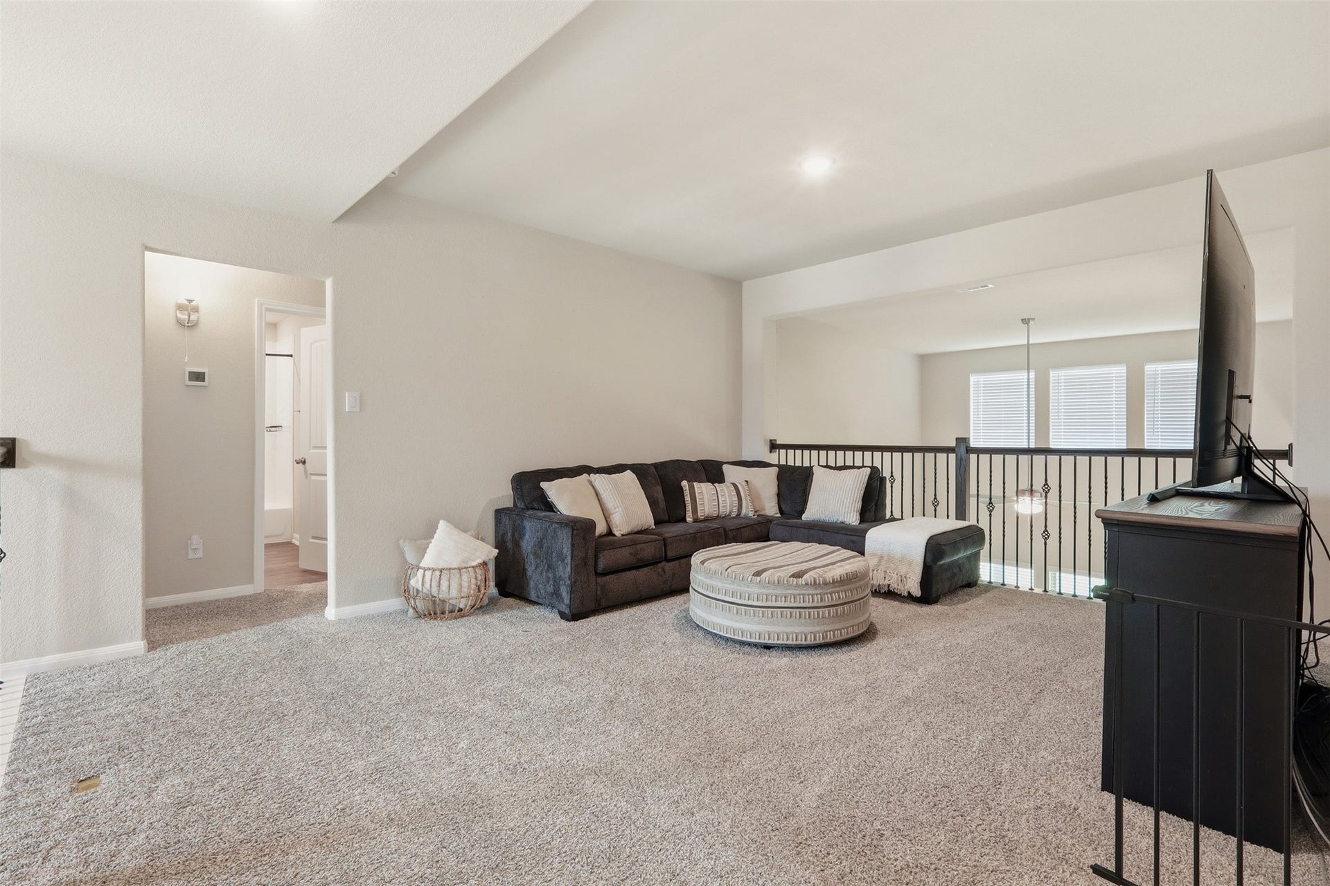 Spacious game room featuring abundant natural light, open sightlines to the living area below, and plenty of space for entertainment and recreation.
