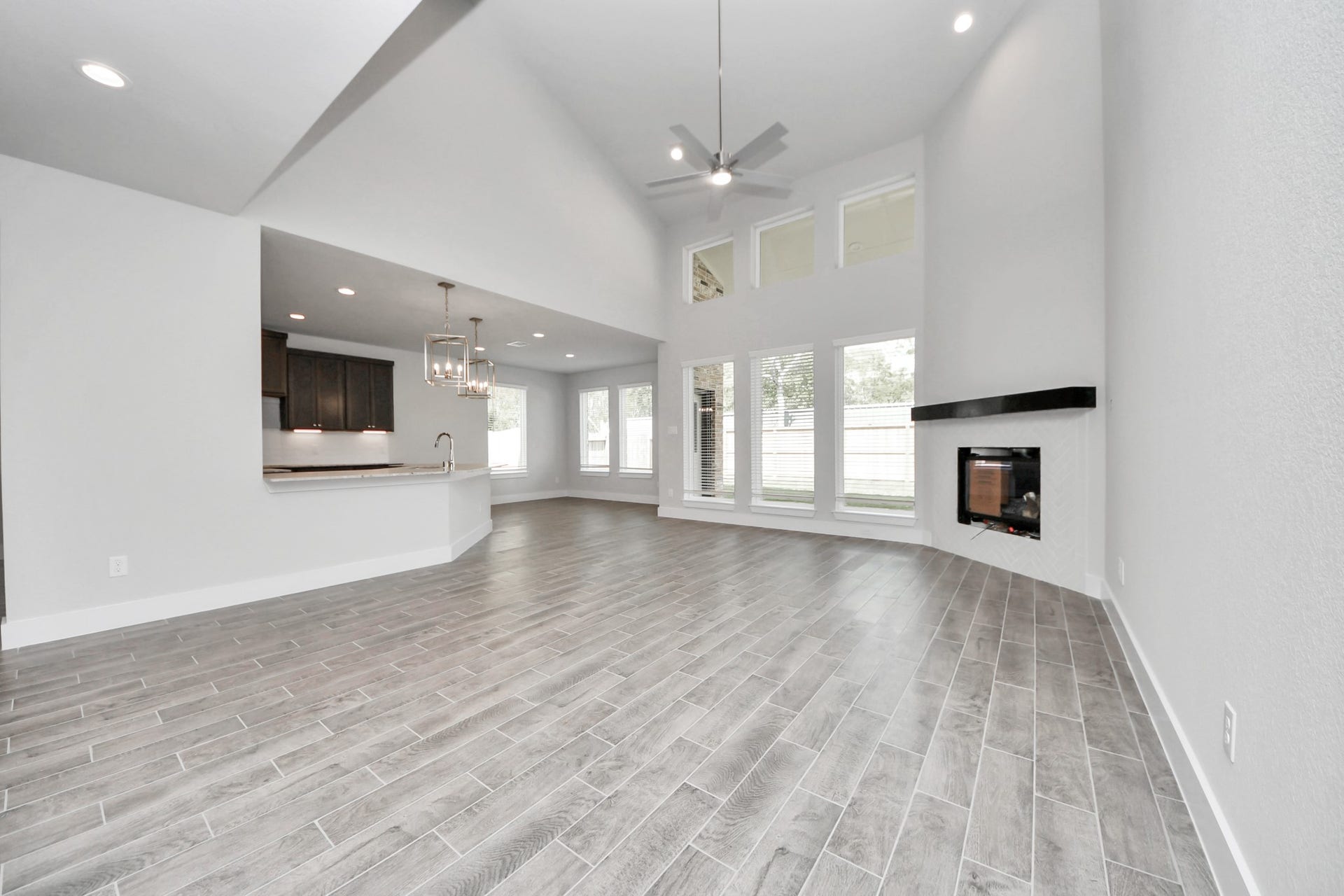 3213 Skerne Spring Drive, Spring, TX 77373 Family room flooded with natural light through the expansive windows. The premium tile flooring adds a touch of luxury to the space, creating the perfect setting for relaxing moments and cherished gatherings with loved ones. Sample photo of completed home with similar floor plan. Actual colors and selections may vary.