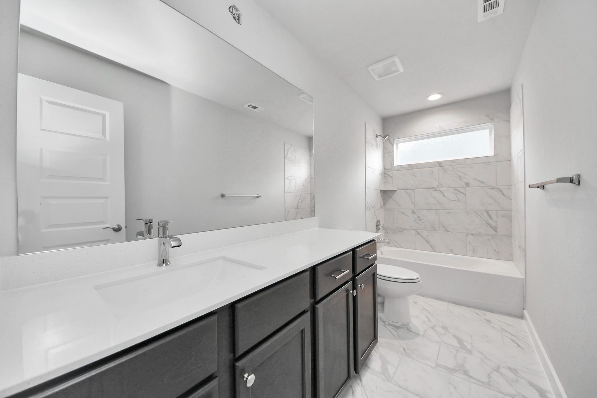 3213 Skerne Spring Drive, Spring, TX 77373 Secondary bath features tile flooring, bath/shower combo with tile surround, light stained wood cabinets, beautiful light countertop. Sample photo of completed home with similar floor plan. Actual colors and selections may vary.