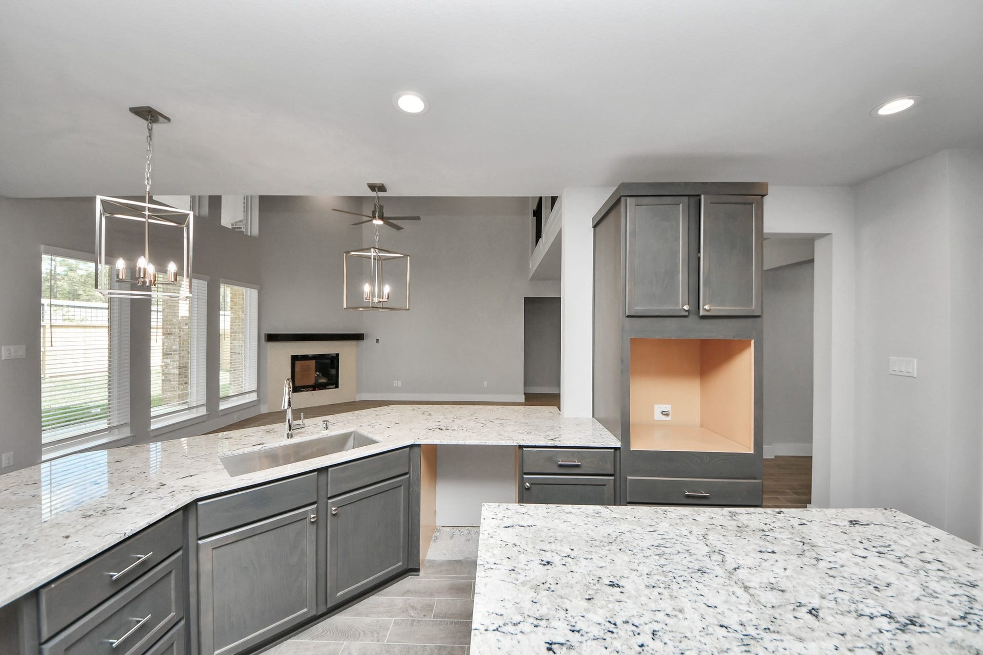 3213 Skerne Spring Drive, Spring, TX 77373 This kitchen is truly a chef's dream! This haven Boasts high ceilings, recessed & pendant lighting, stained wood cabinets, granite countertops, stainless steel appliances, a modern tile backsplash. All of this overlooks your expansive family room, creating a perfect space for culinary delights and family gatherings. Sample photo of completed home with similar floor plan. Actual colors and selections may vary.