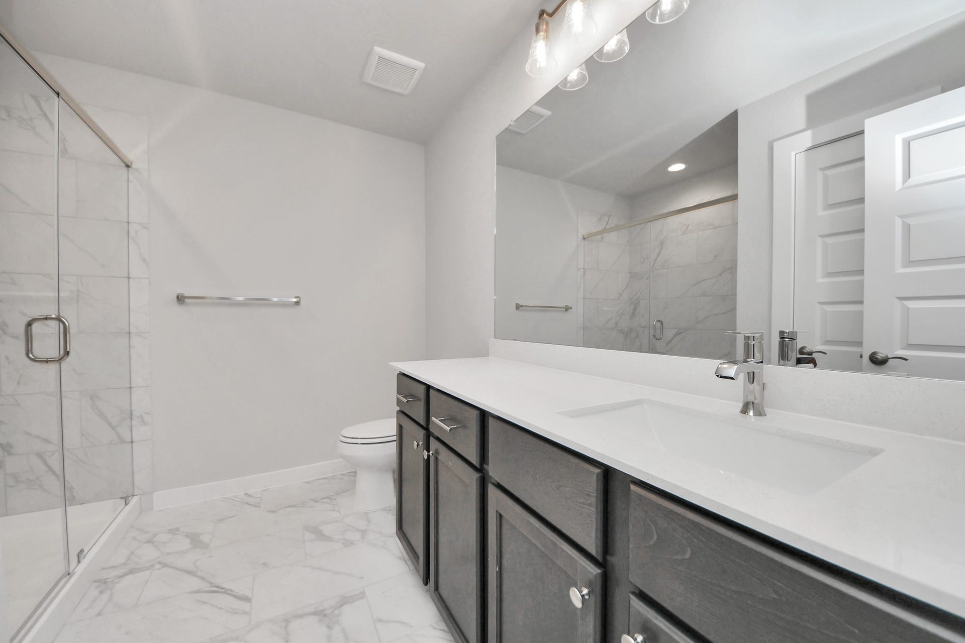 3213 Skerne Spring Drive, Spring, TX 77373 Secondary bath features tile flooring, walk-in shower with tile surround, light stained wood cabinets, beautiful light countertop. Sample photo of completed home with similar floor plan. Actual colors and selections may vary.