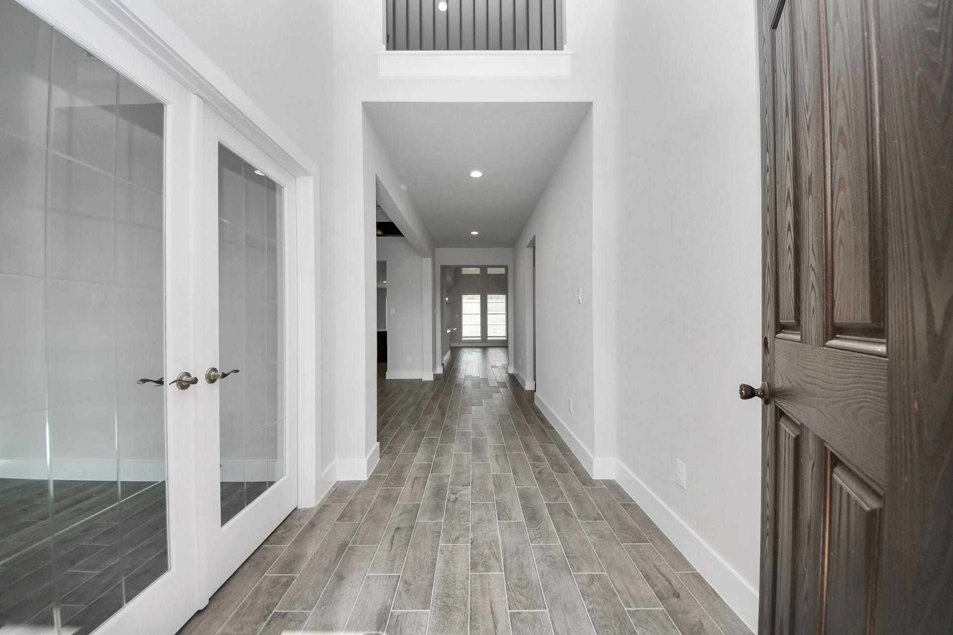 3213 Skerne Spring Drive, Spring, TX 77373 As you step into the threshold of this luxurious home, you'll soon be welcomed by an elegant glass door (to be installed). Inside, soaring ceilings amplify the spaciousness, while the refined wood-look tile flooring and oversized baseboards exude sophistication and charm. Sample photo of completed home with similar floor plan. Actual colors and selections may vary.