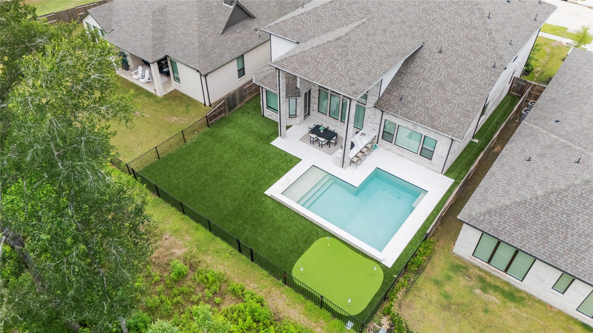 4439 Southpoint Way, Fulshear, TX 77441 This view really captures the turf covered backyard, the pool and the putting green.