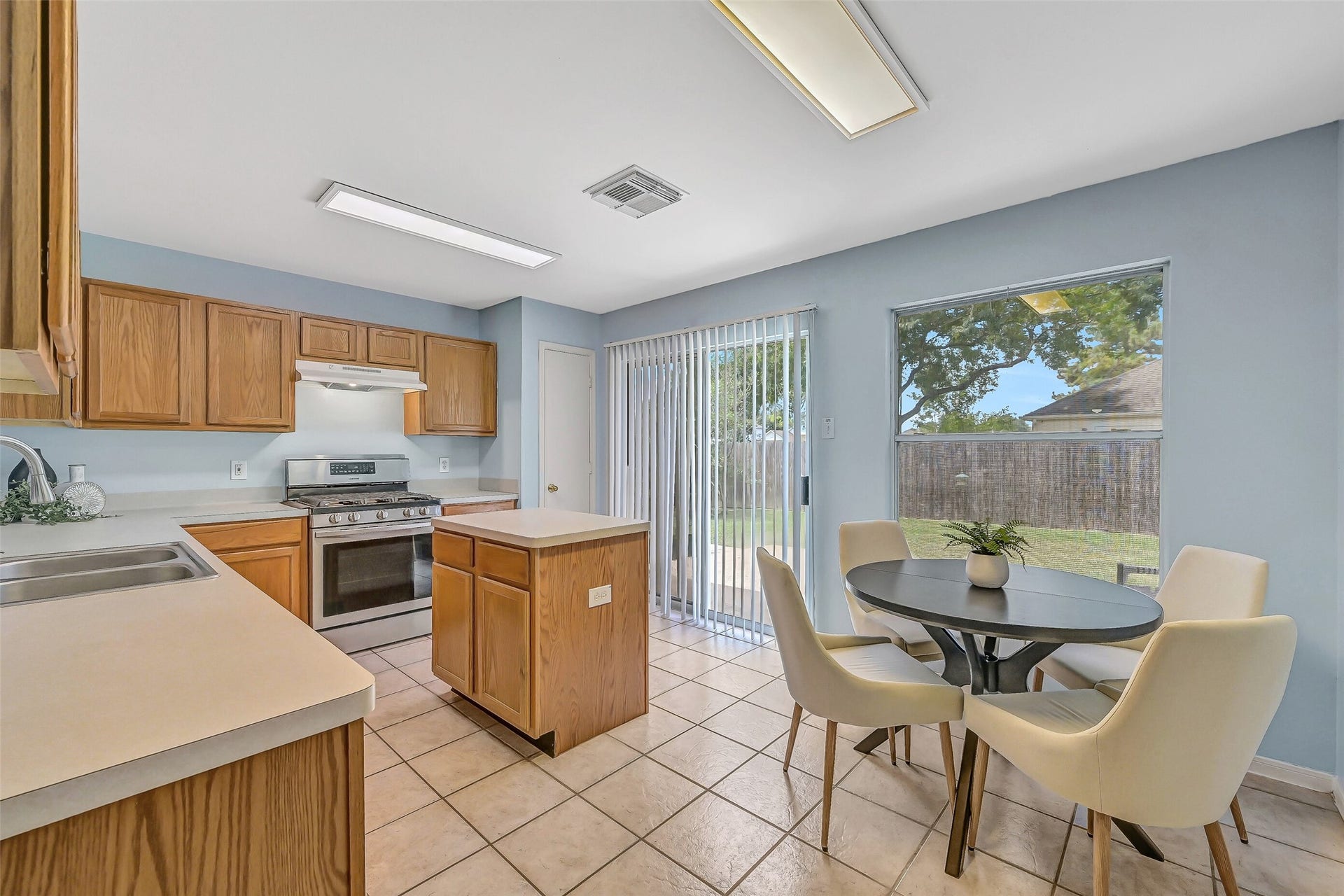 3115 Berryfield Lane, Pearland, TX 77581 The island kitchen offers abundant cabinetry & counter space, a 5-burner Samsung gas range, pantry and sunny breakfast area overlooking the backyard. A sliding glass door provides direct patio access, while the pass-through serving bar keeps the kitchen connected to the family room.