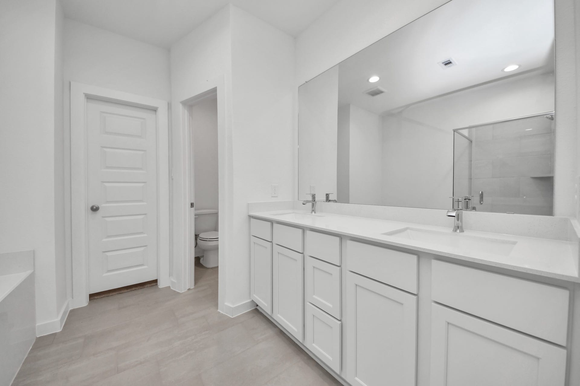 18551 Athena Flower Drive, Fresno, TX 77545 Elevate your daily routine at the elegant vanity, now equipped with double sinks, light countertops, modern hardware, and beautiful recessed lights. Sample photo of completed home with similar floor plan. Actual colors and selections may vary.